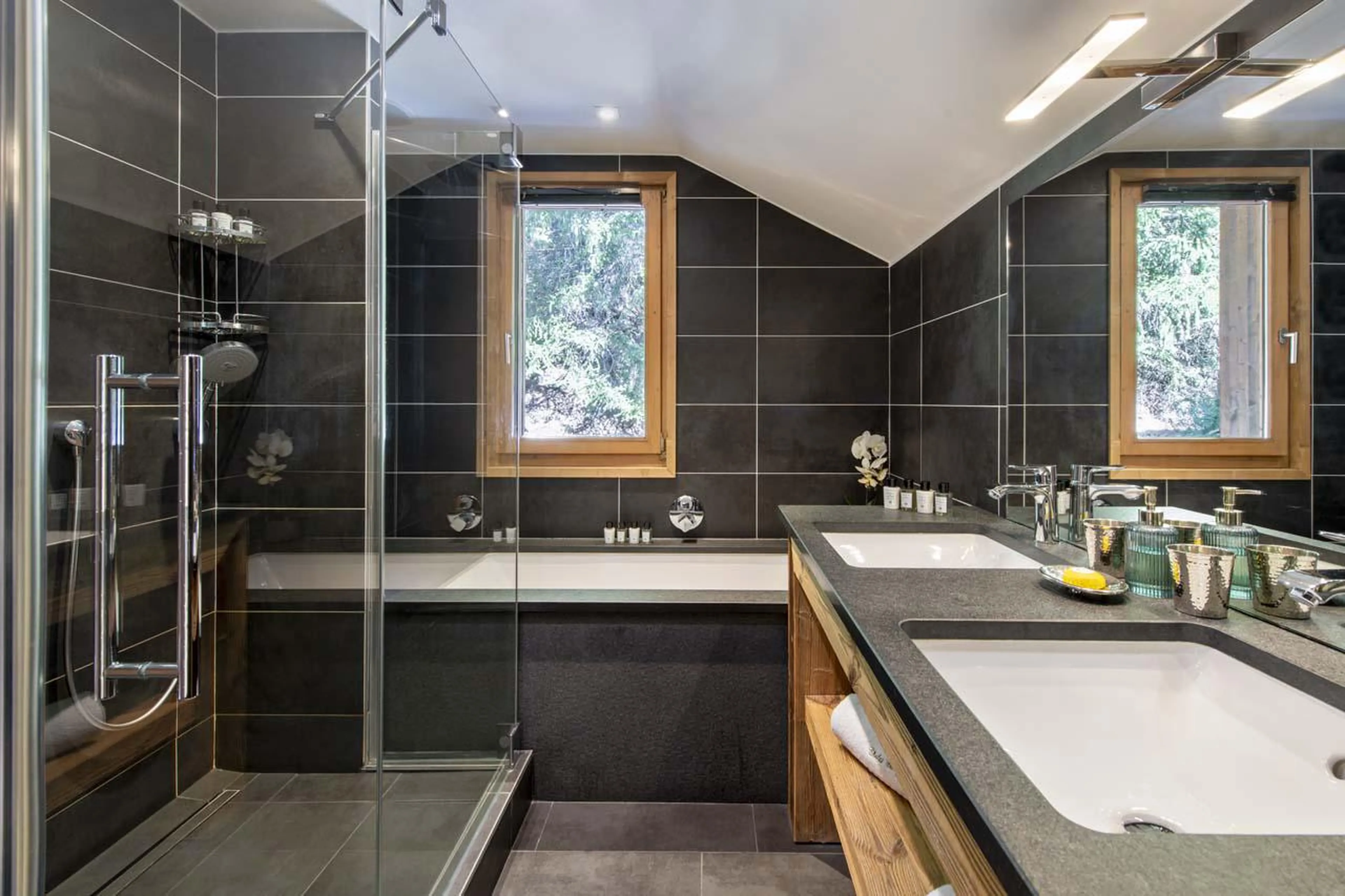 En-suite bathroom with bath and shower at Chalet Genepi in Meribel