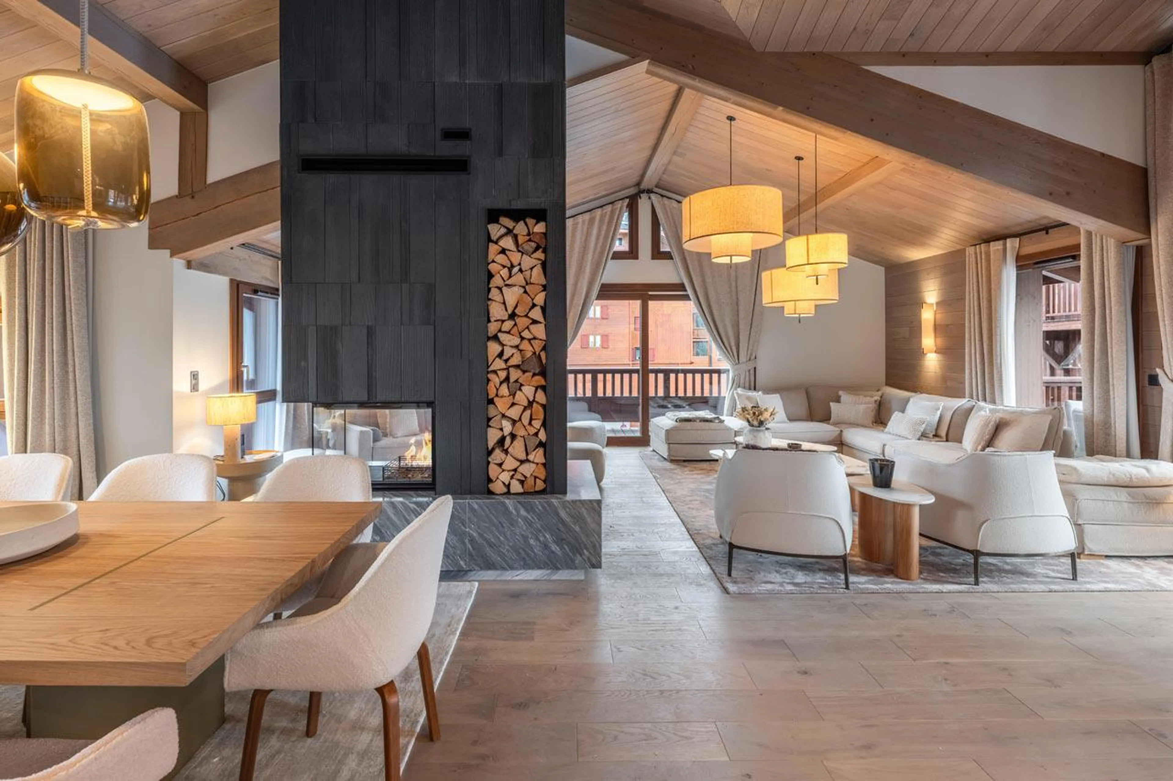 Central fireplace dividing dining and sitting area in Chalet Goyard, Courchevel 1650