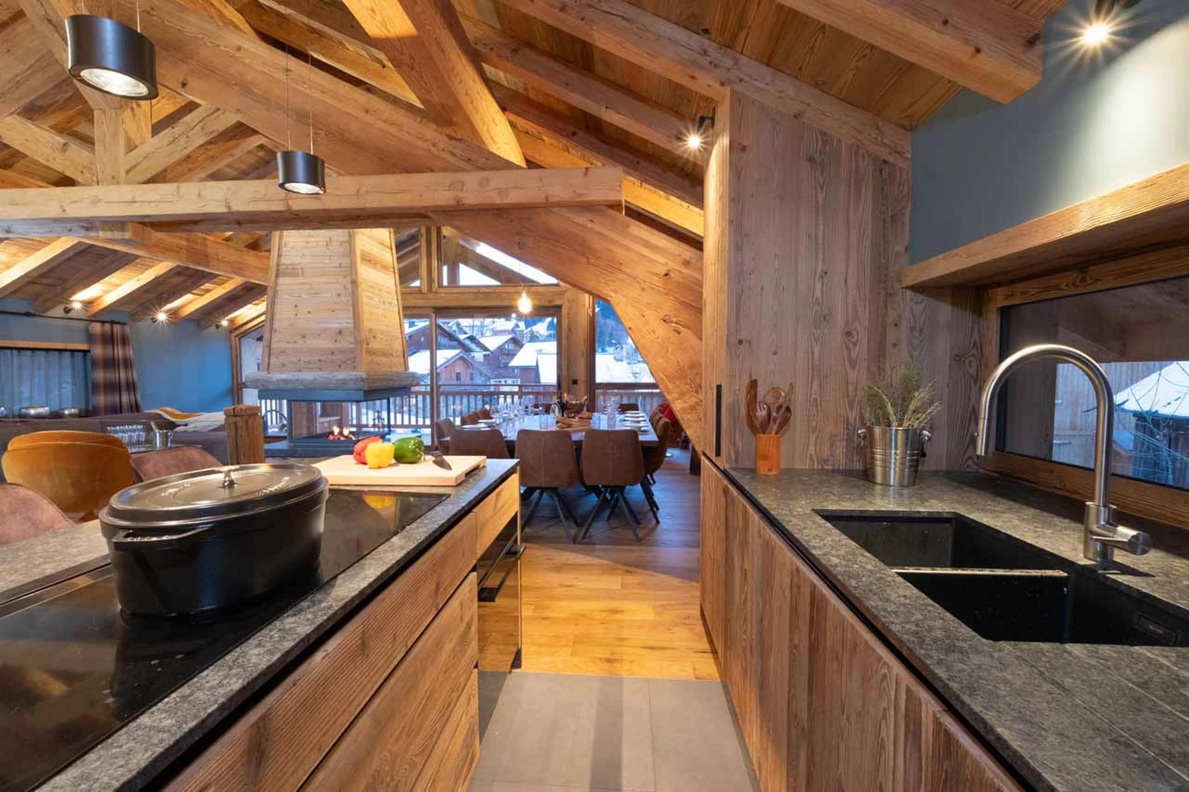 Kitchen flowing into sitting area with fireplace in Chalet Grande Kalinka, Meribel