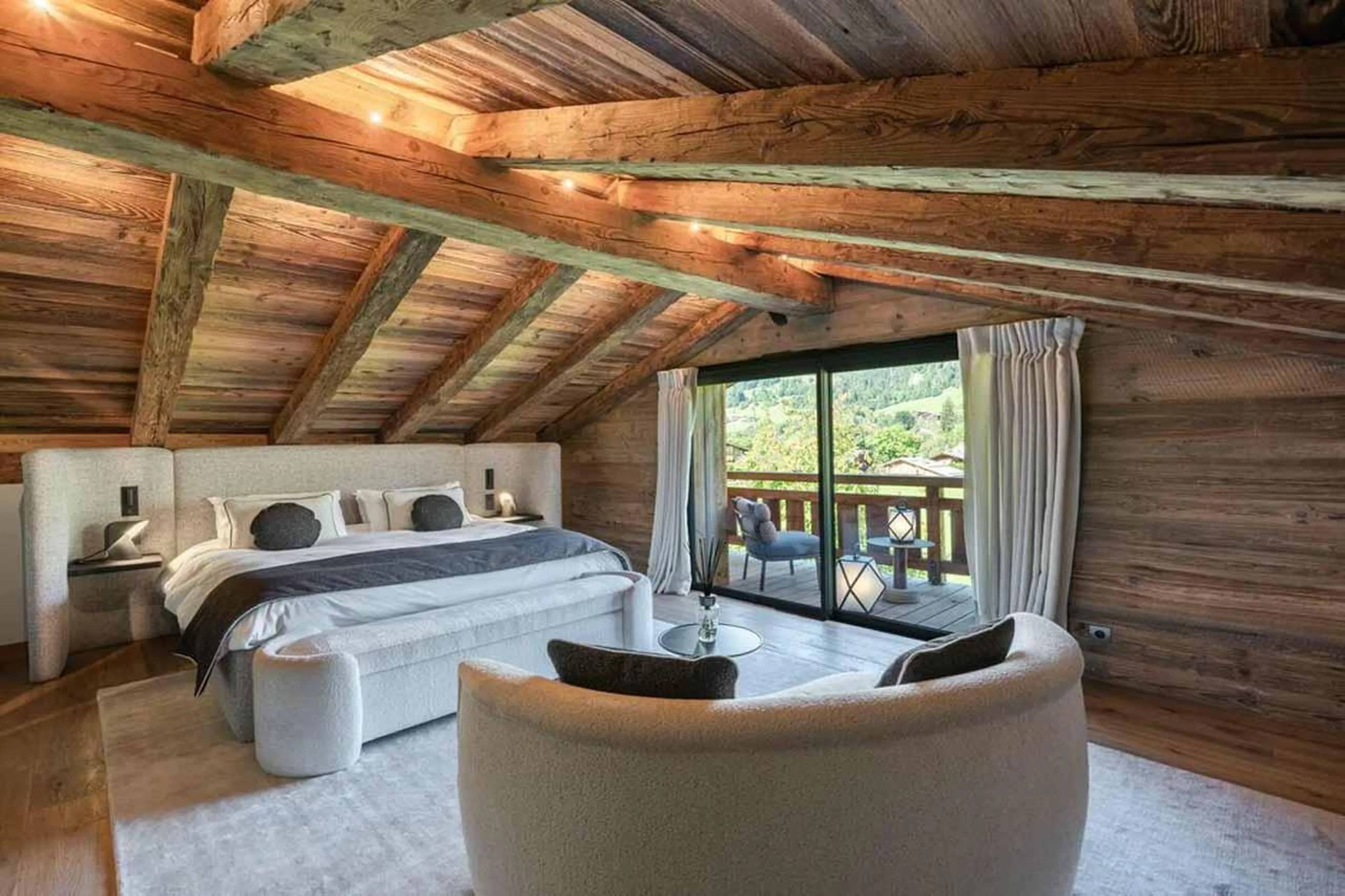 Double bedroom with sofa and sliding glass doors in Chalet Grizzly, Megeve