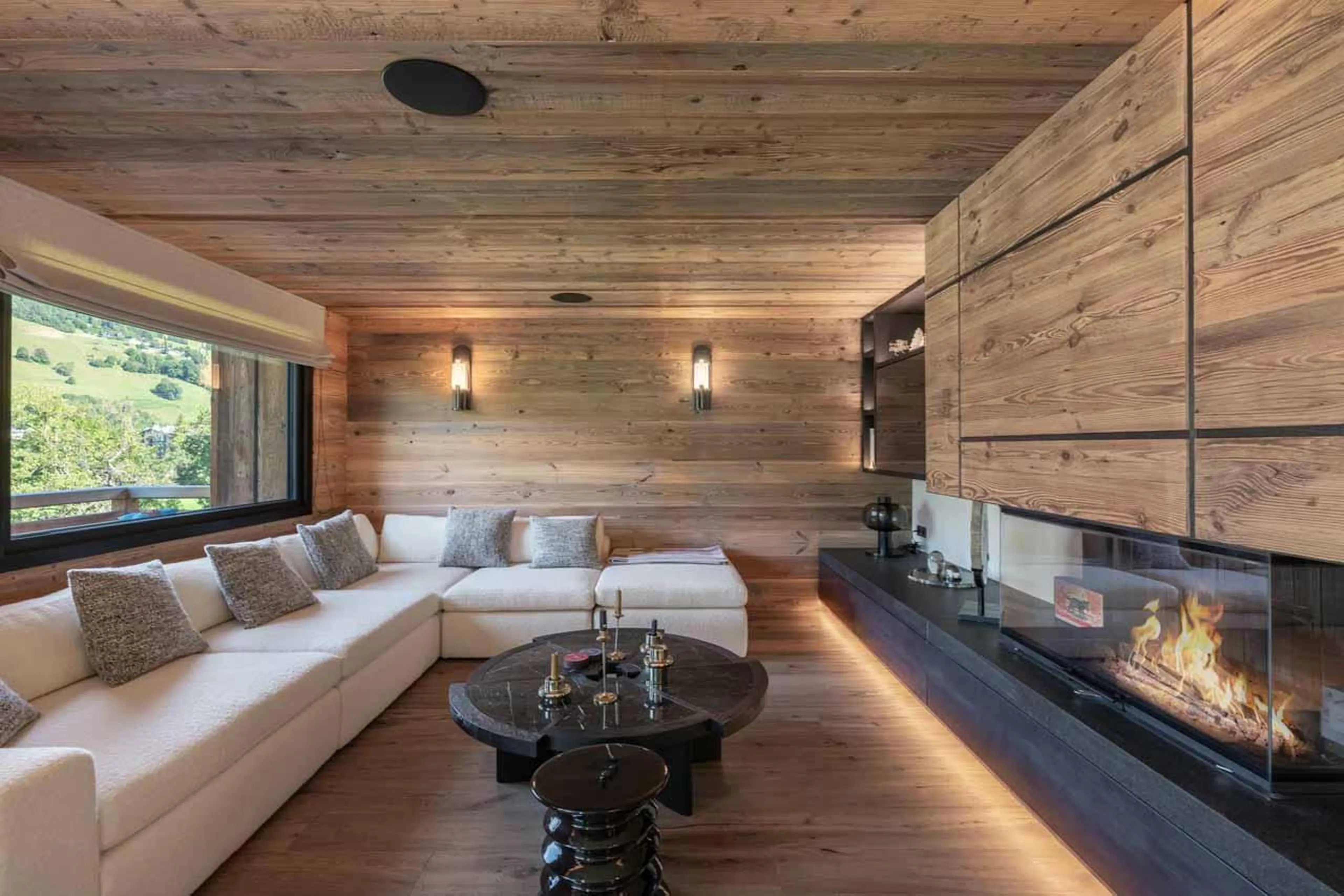 White corner sofa and fireplace in Chalet Grizzly, Megeve