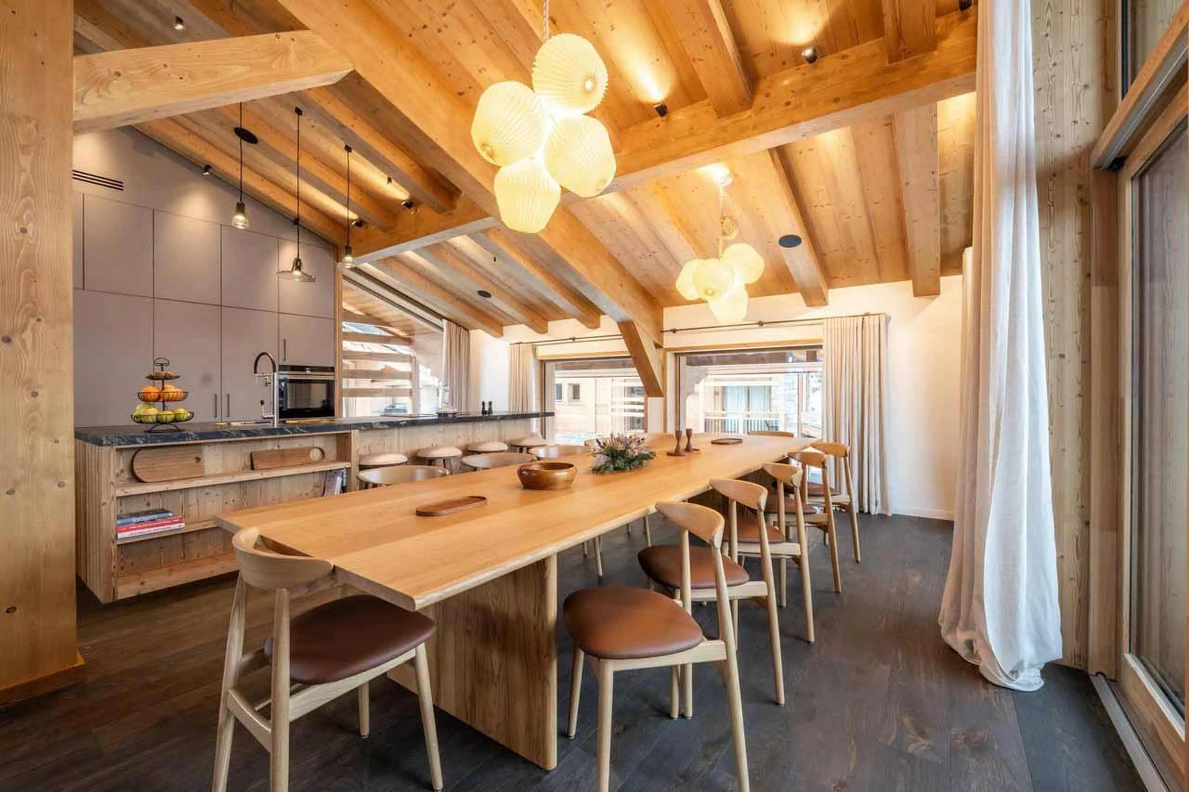 Dining table beneath stylish lighting in Chalet Irbis, Courchevel Le Praz