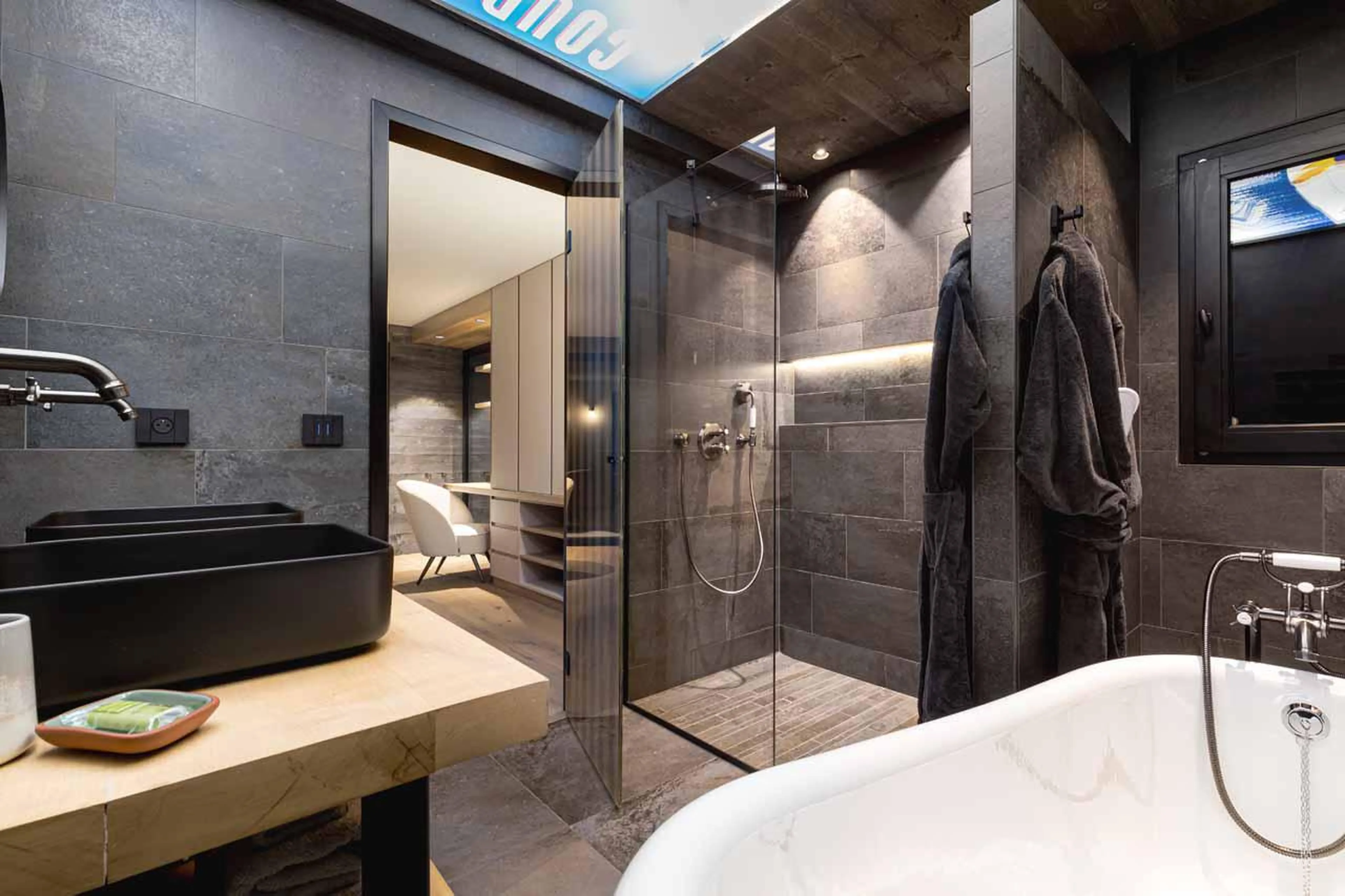 En-suite bathroom with bath and walk-in shower at Chalet Kandahar in Courchevel 1550