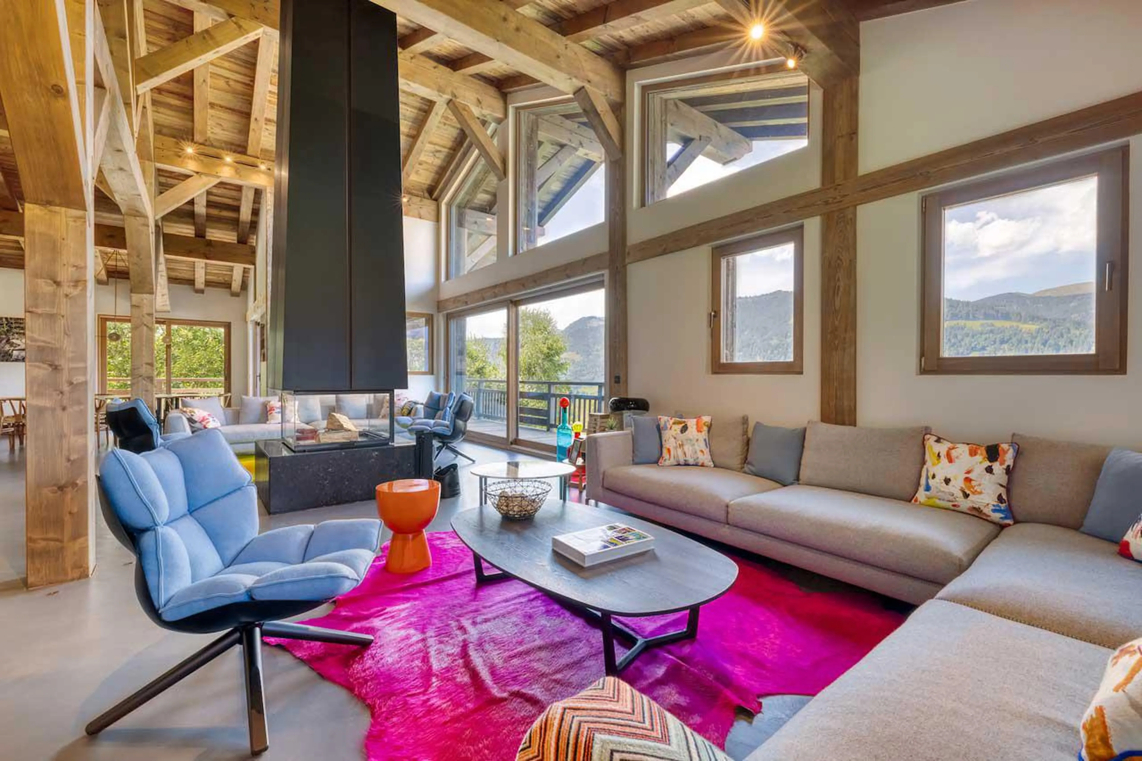 Spacious living area with modern black steel fireplace at Chalet Kantaa in Megeve