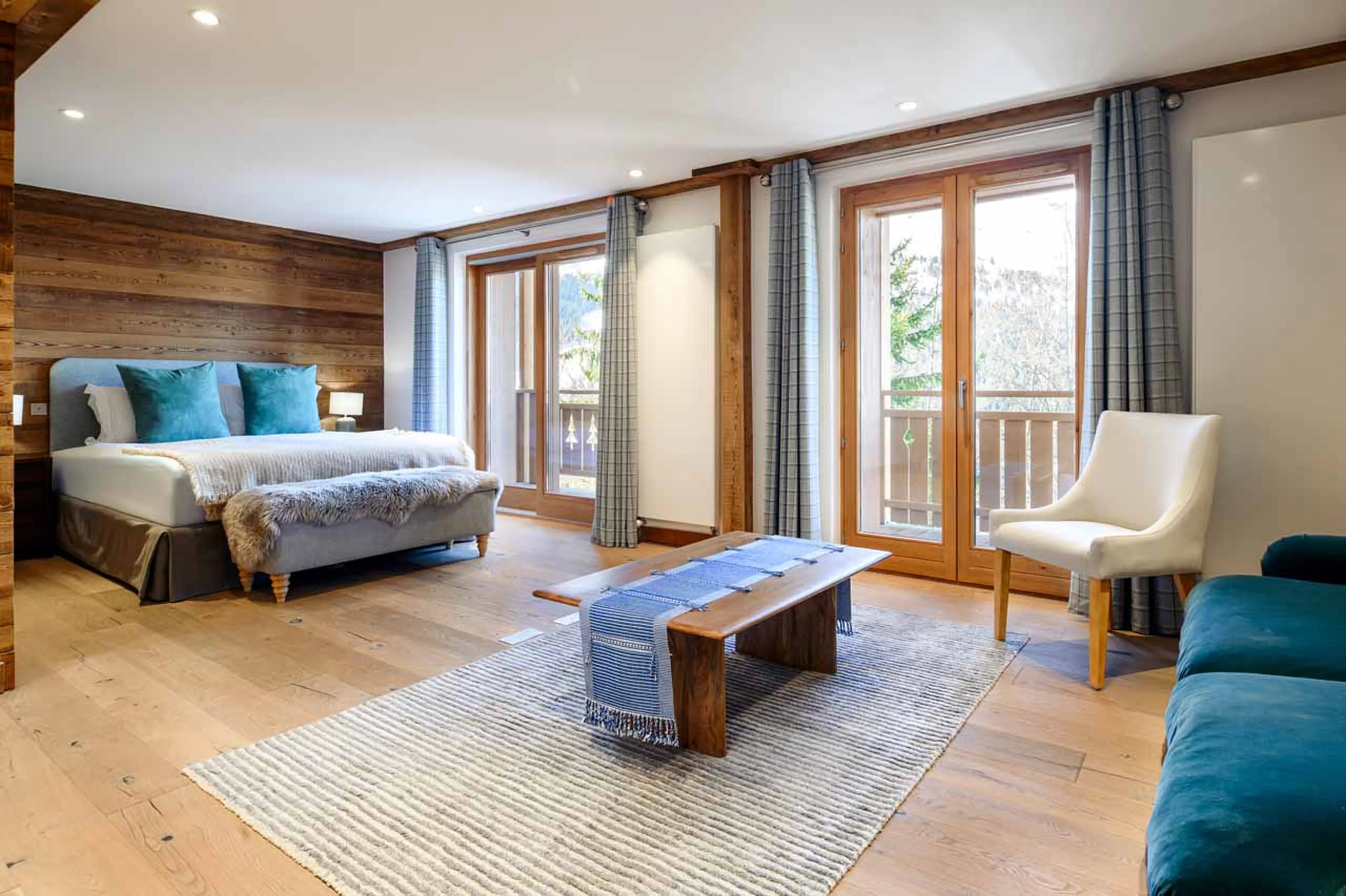 Master bedroom with sofa and private balcony in Chalet La Folie, Meribel