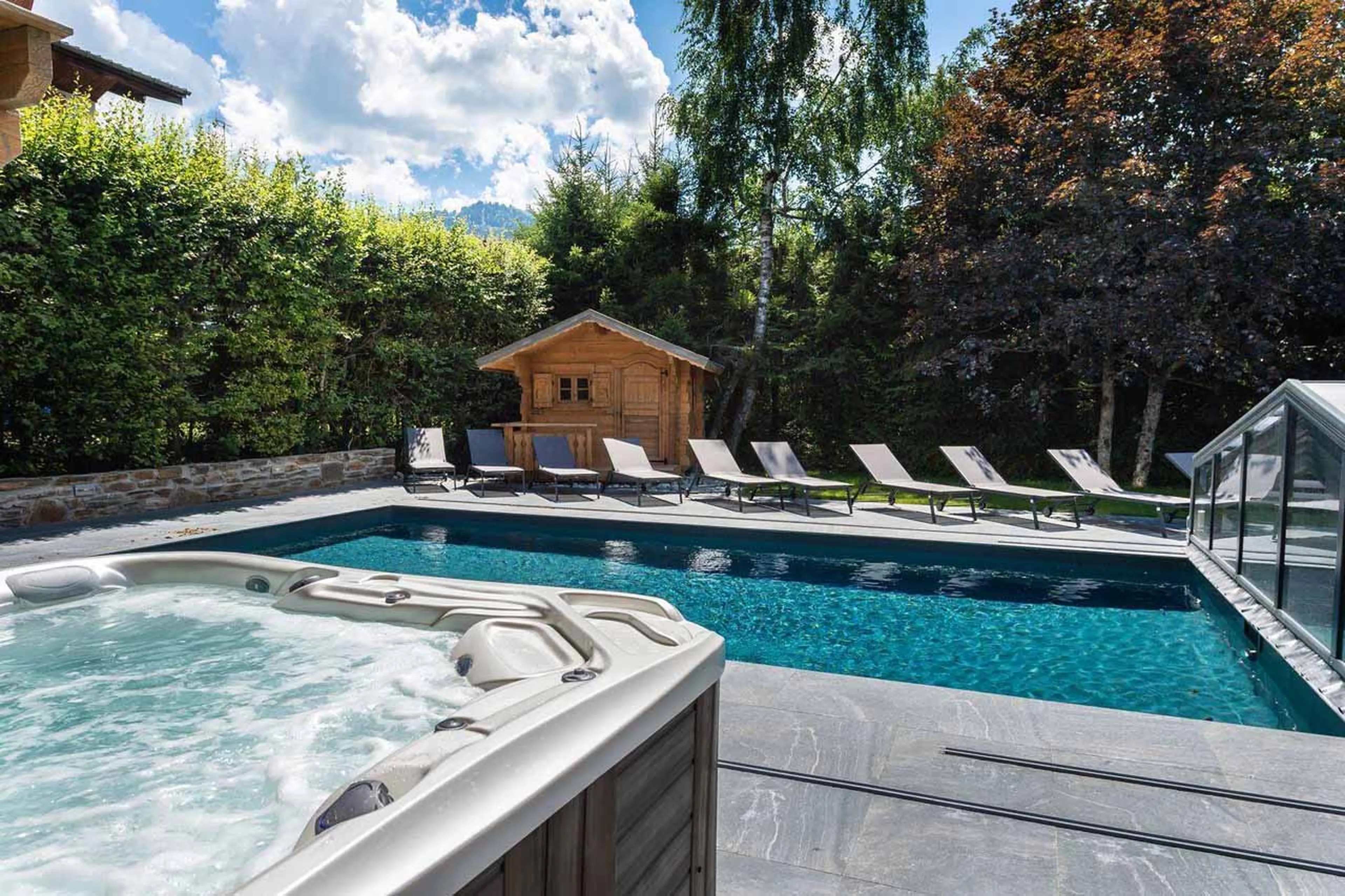 Outdoor pool and hot tub at Chalet Lamartine in Megeve in summer