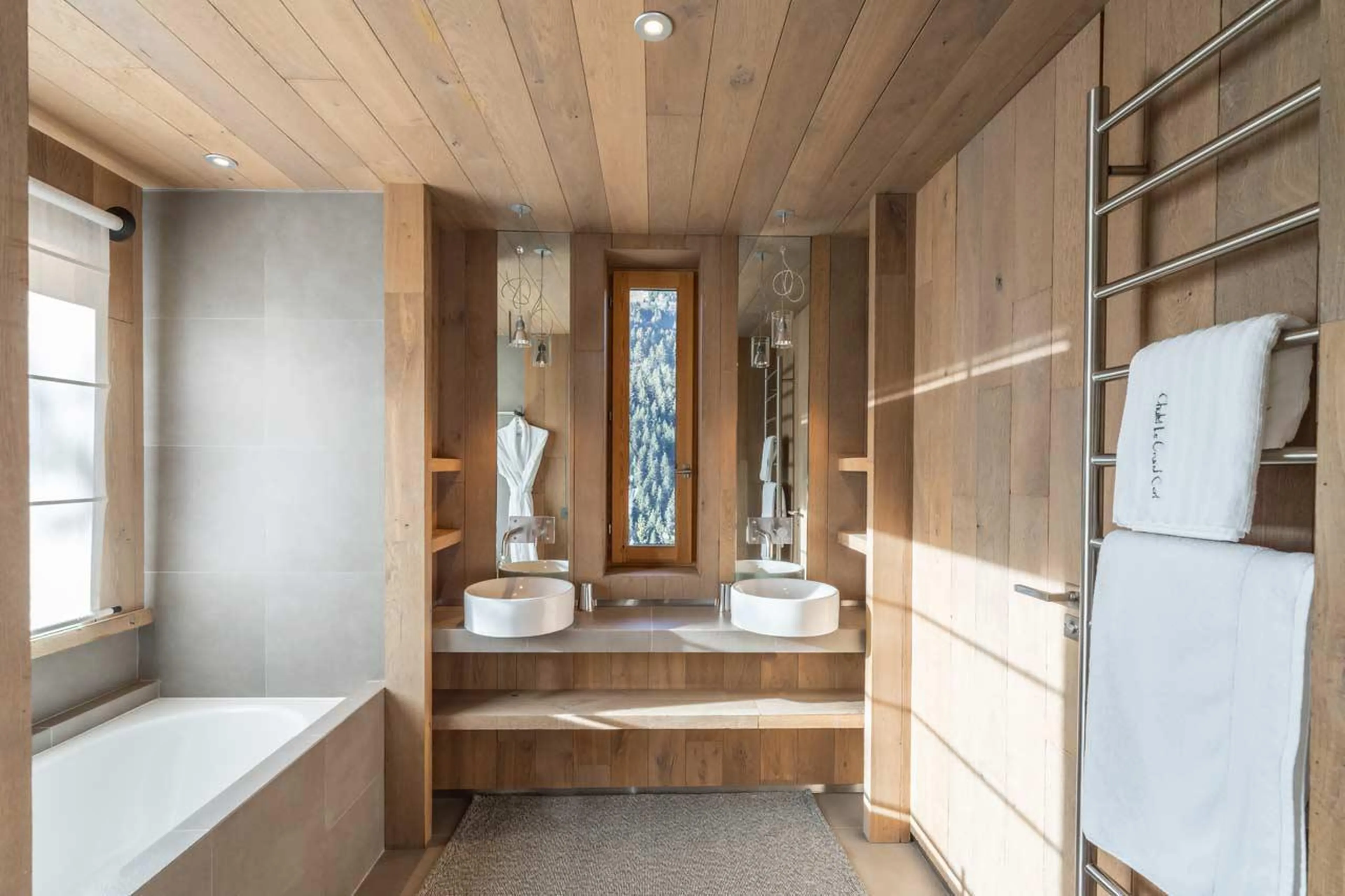 En-suite bathroom with bath and double basin at Le Grand Cerf in Meribel