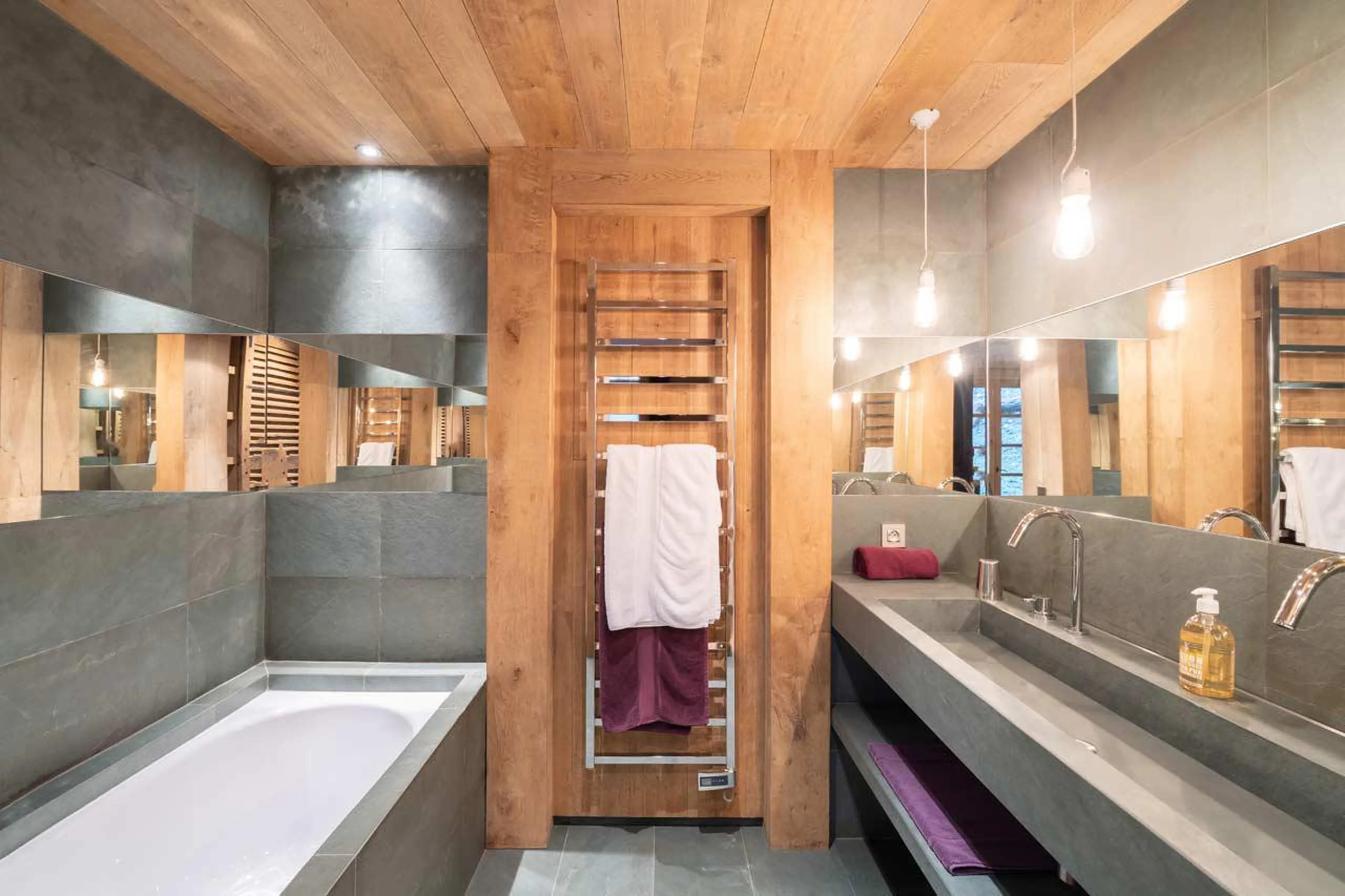 En-suite bathroom with bath and double basin at Le Grand Cerf in Meribel