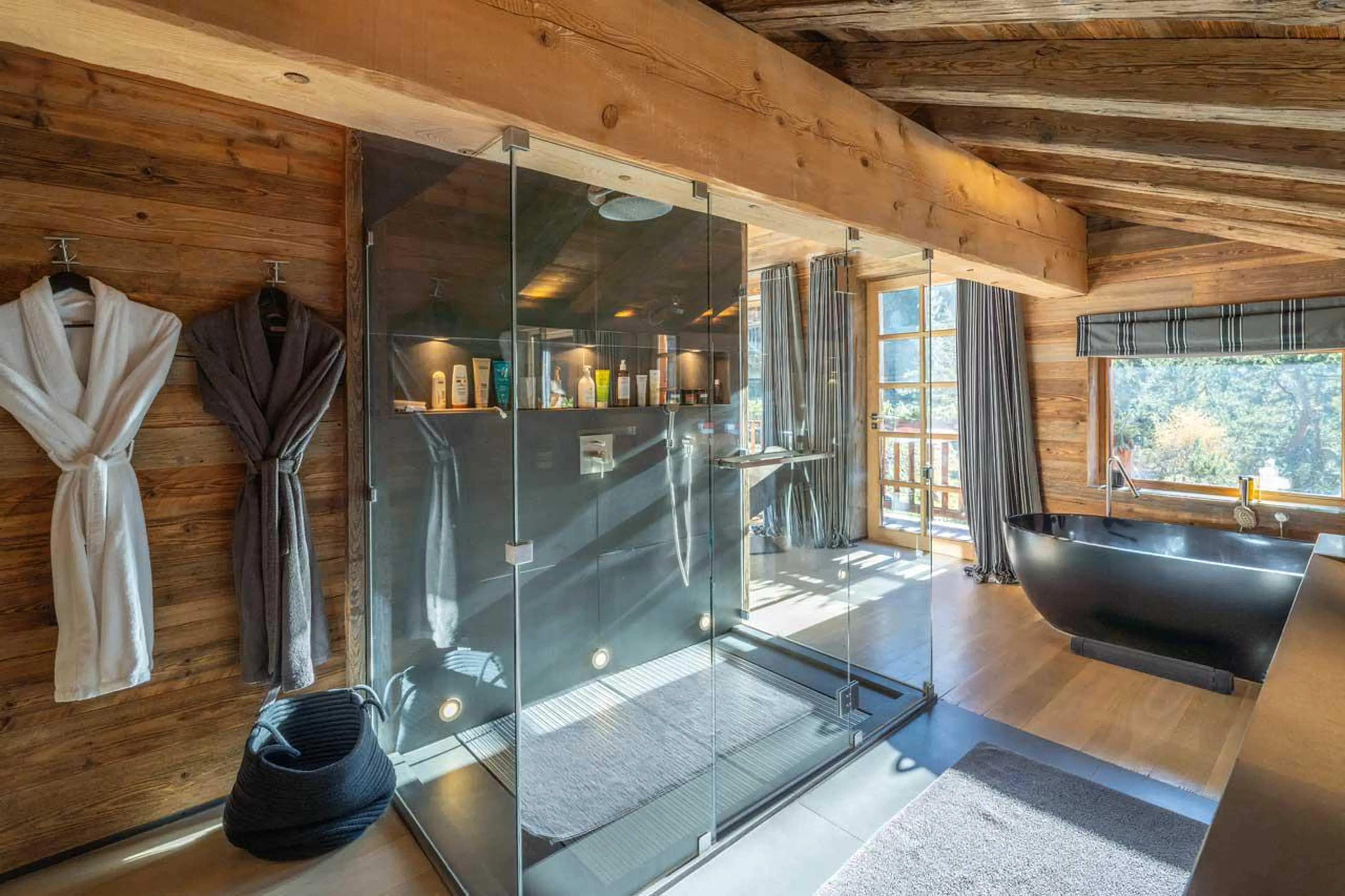 En-suite bathroom with bath and shower at Le Grand Cerf in Meribel
