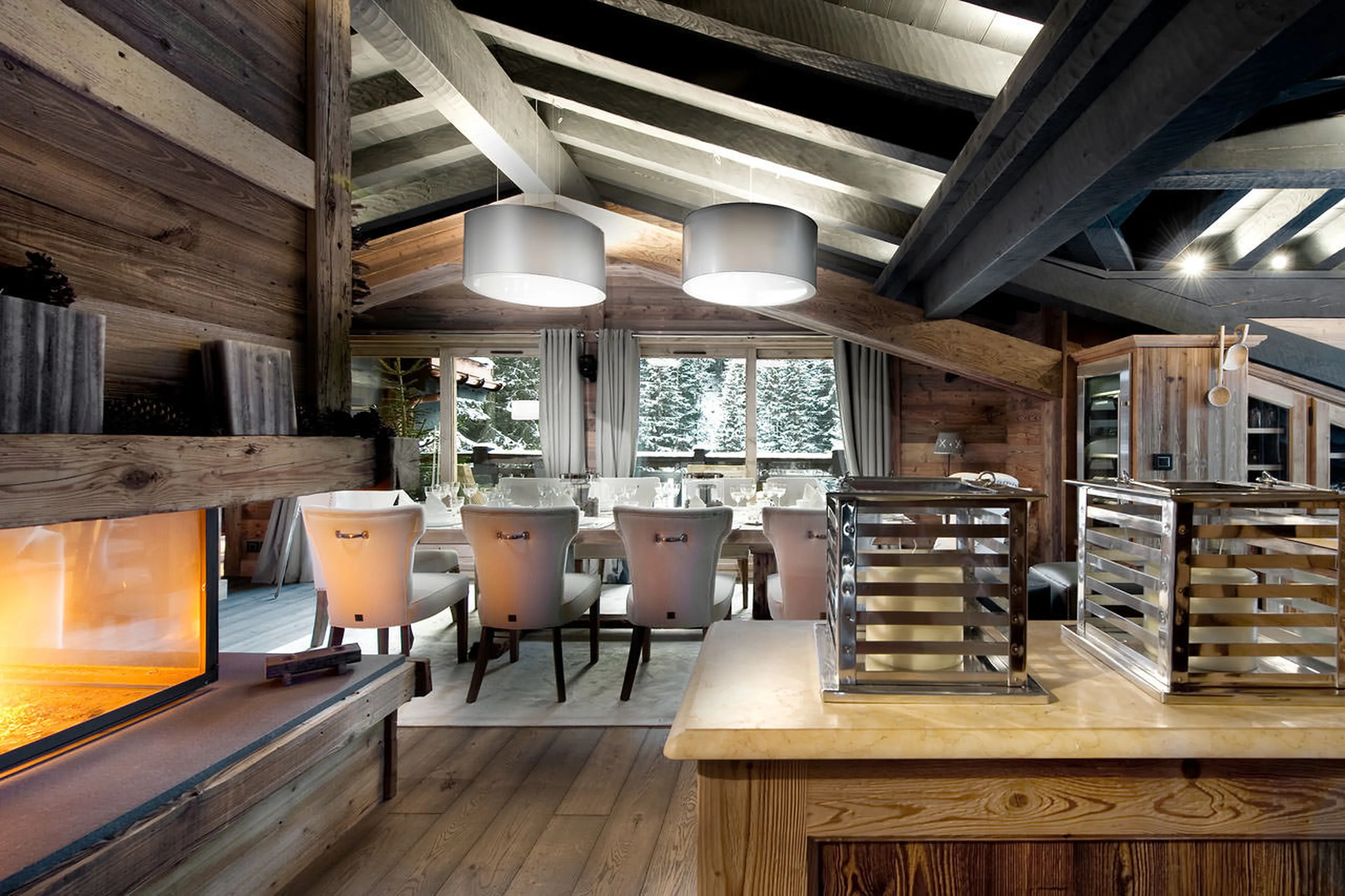 Open plan living area with a central fireplace Chalet Le Petit Chateau in Courchevel 1850