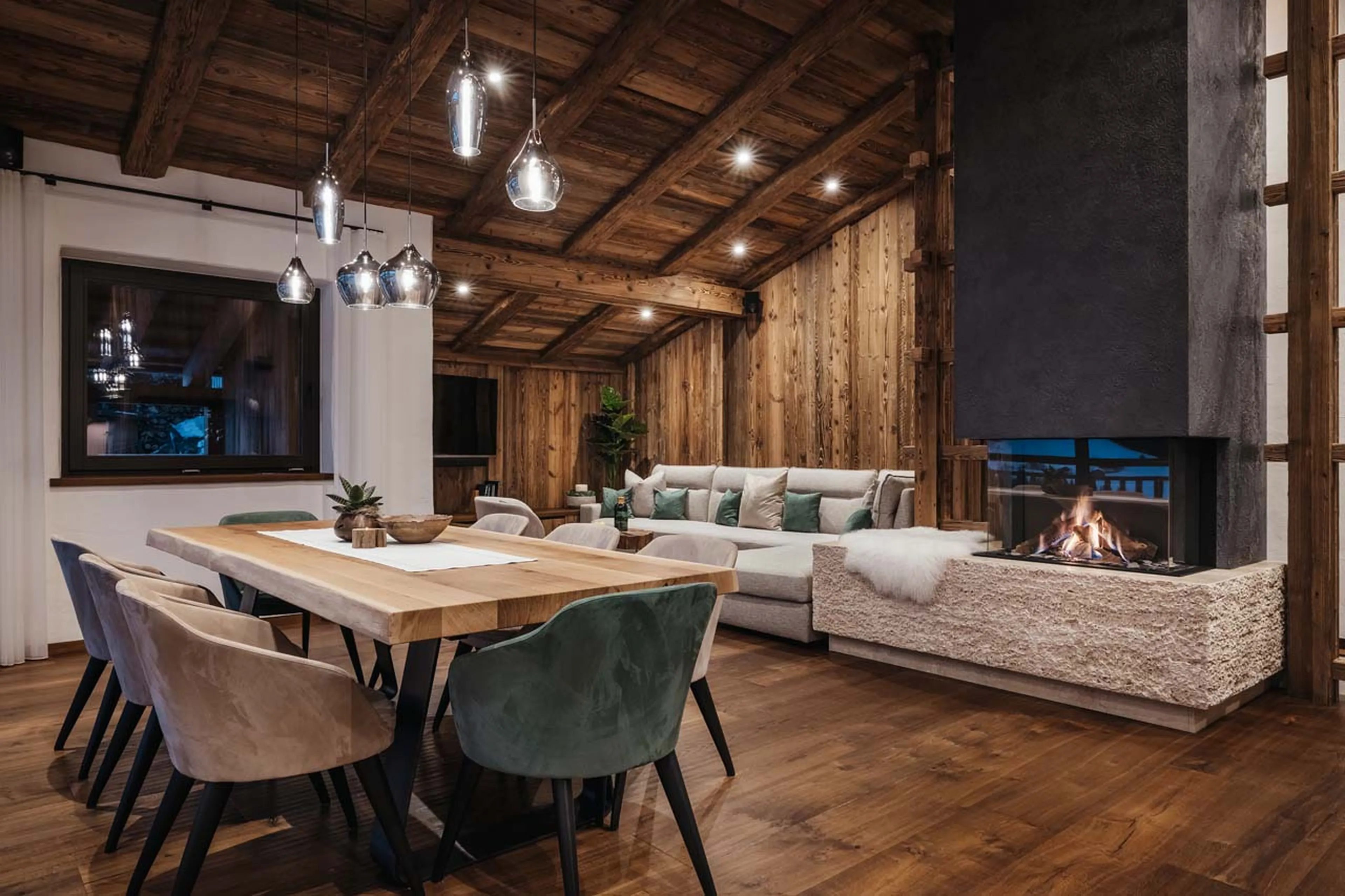 Dining table and central fireplace in Chalet Lefiro, Val Gardena