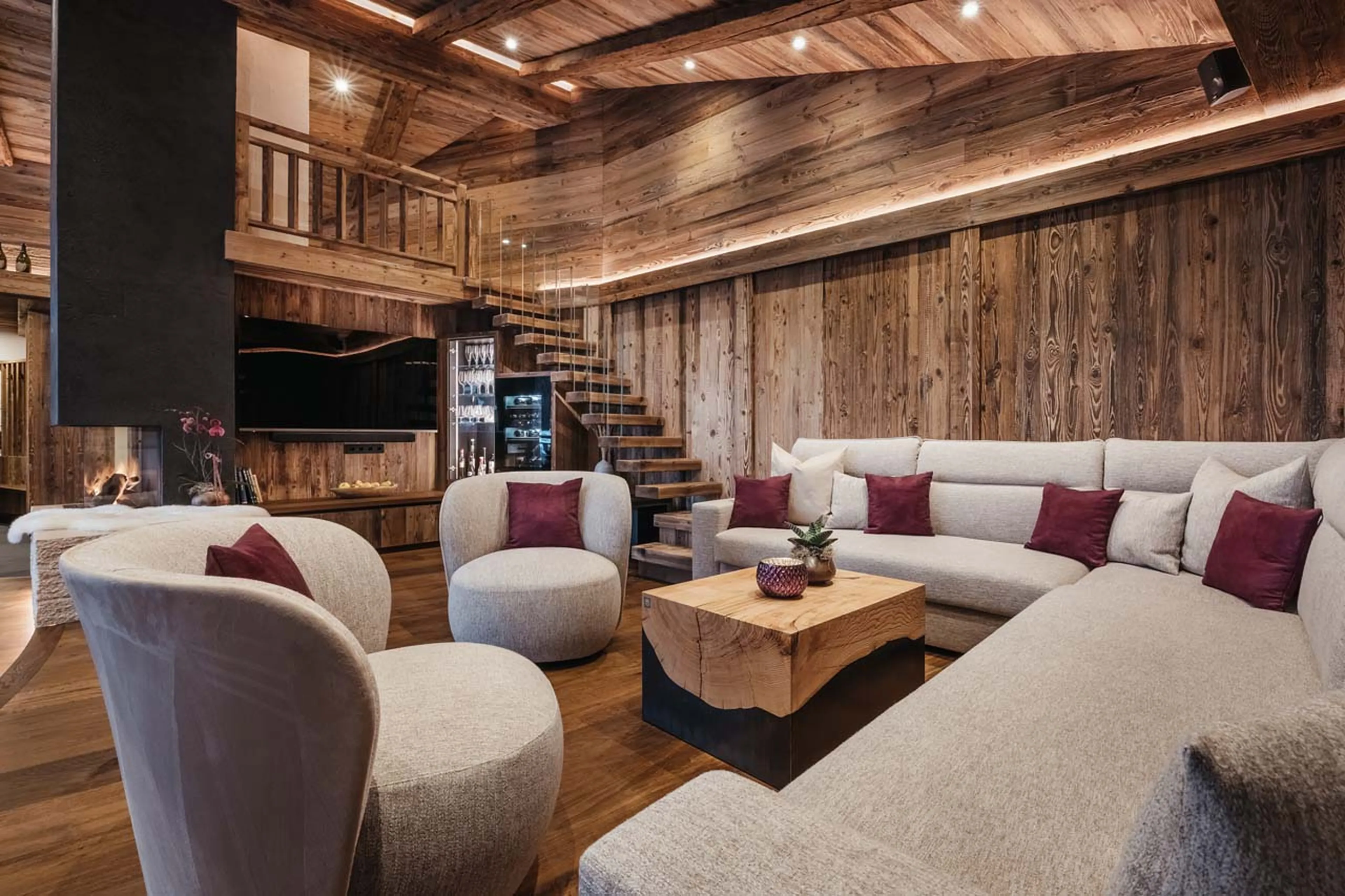 Wrap-around sofa, armchairs and central fireplace in Chalet Lefiro, Val Gardena