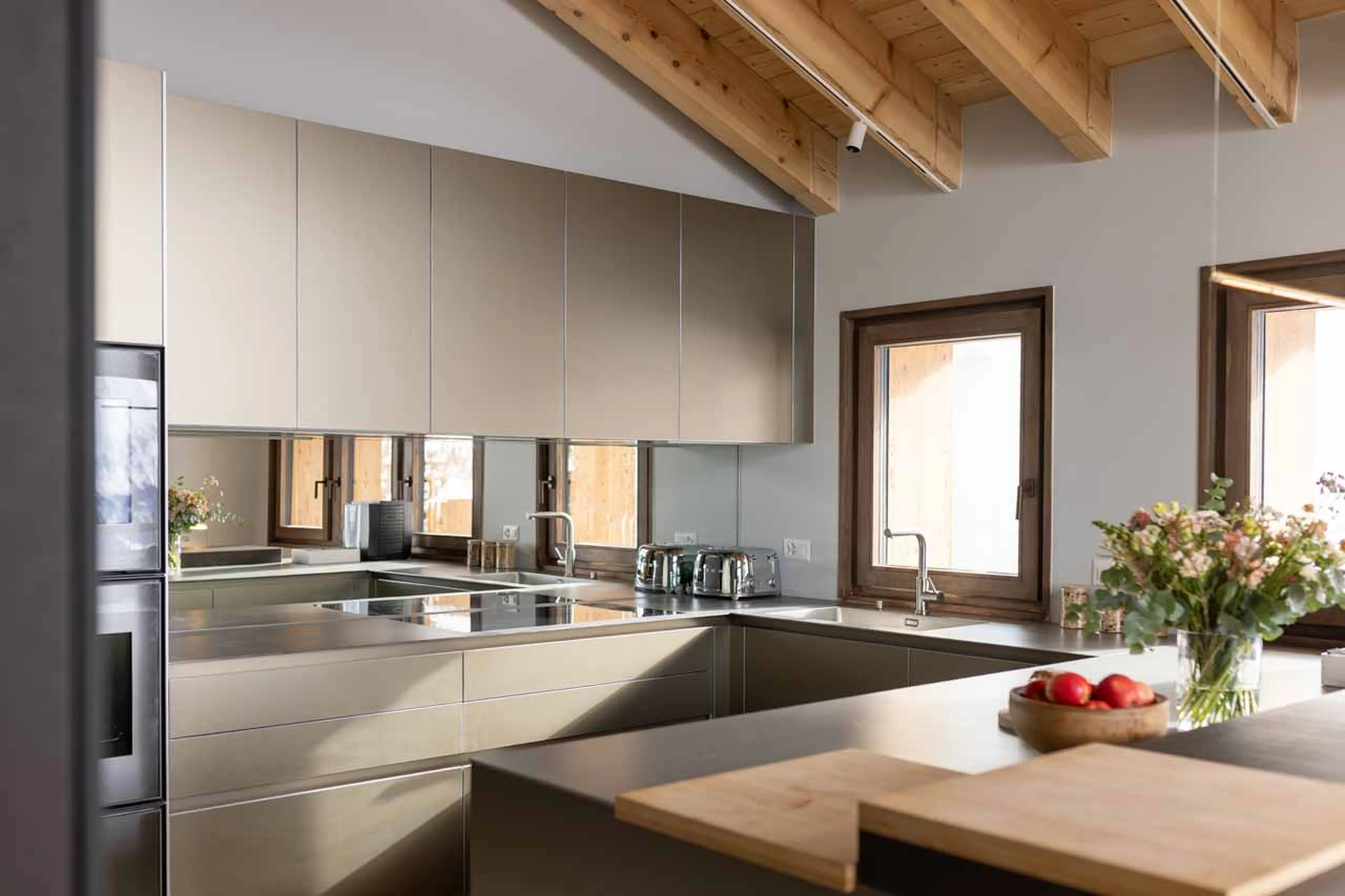 Dining table and kitchen at night at Chalet Les Attelas in Verbier