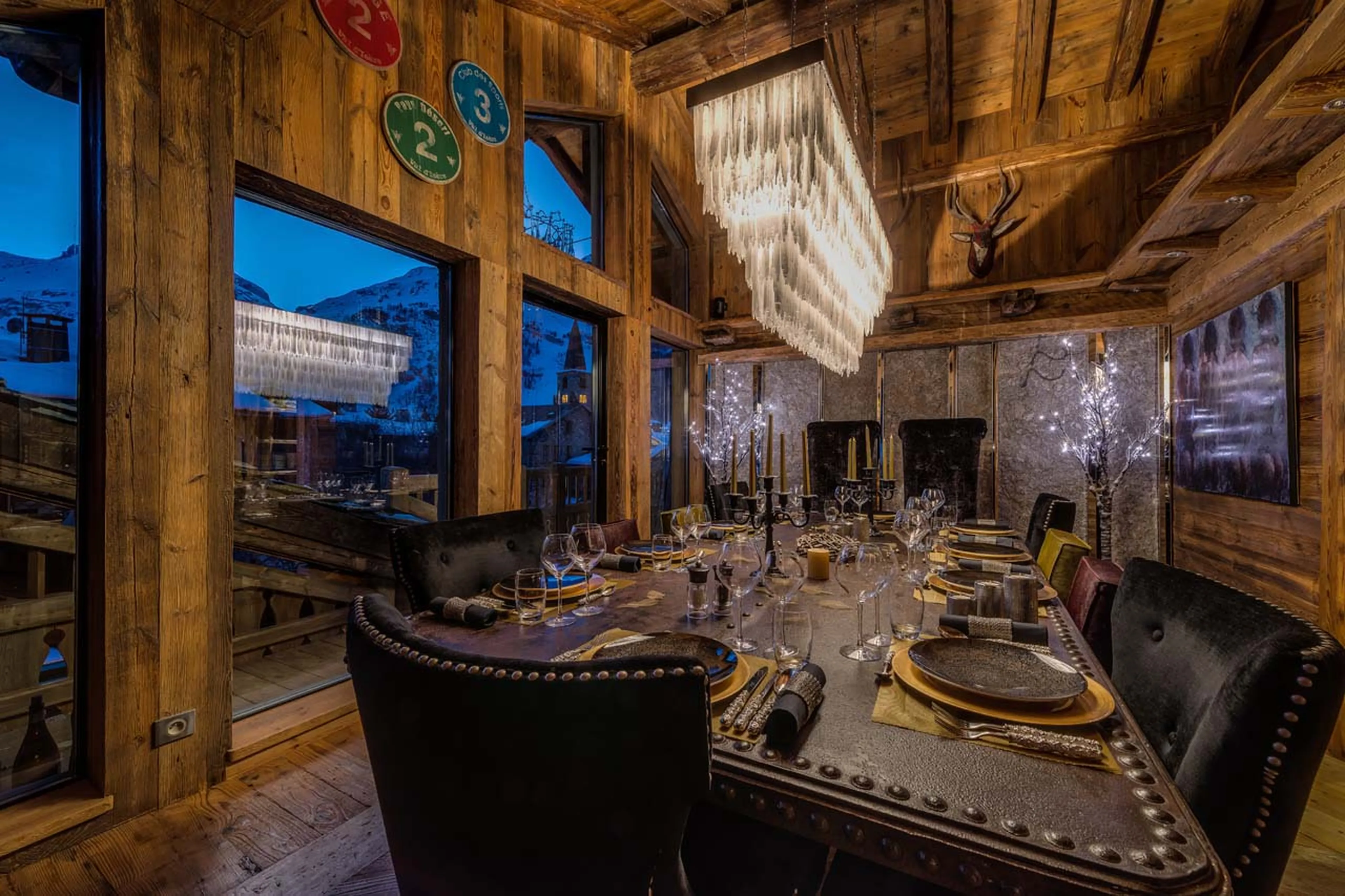 Dining area at long table with views over La face piste in Chalet Lhotse in Val d’ Isere