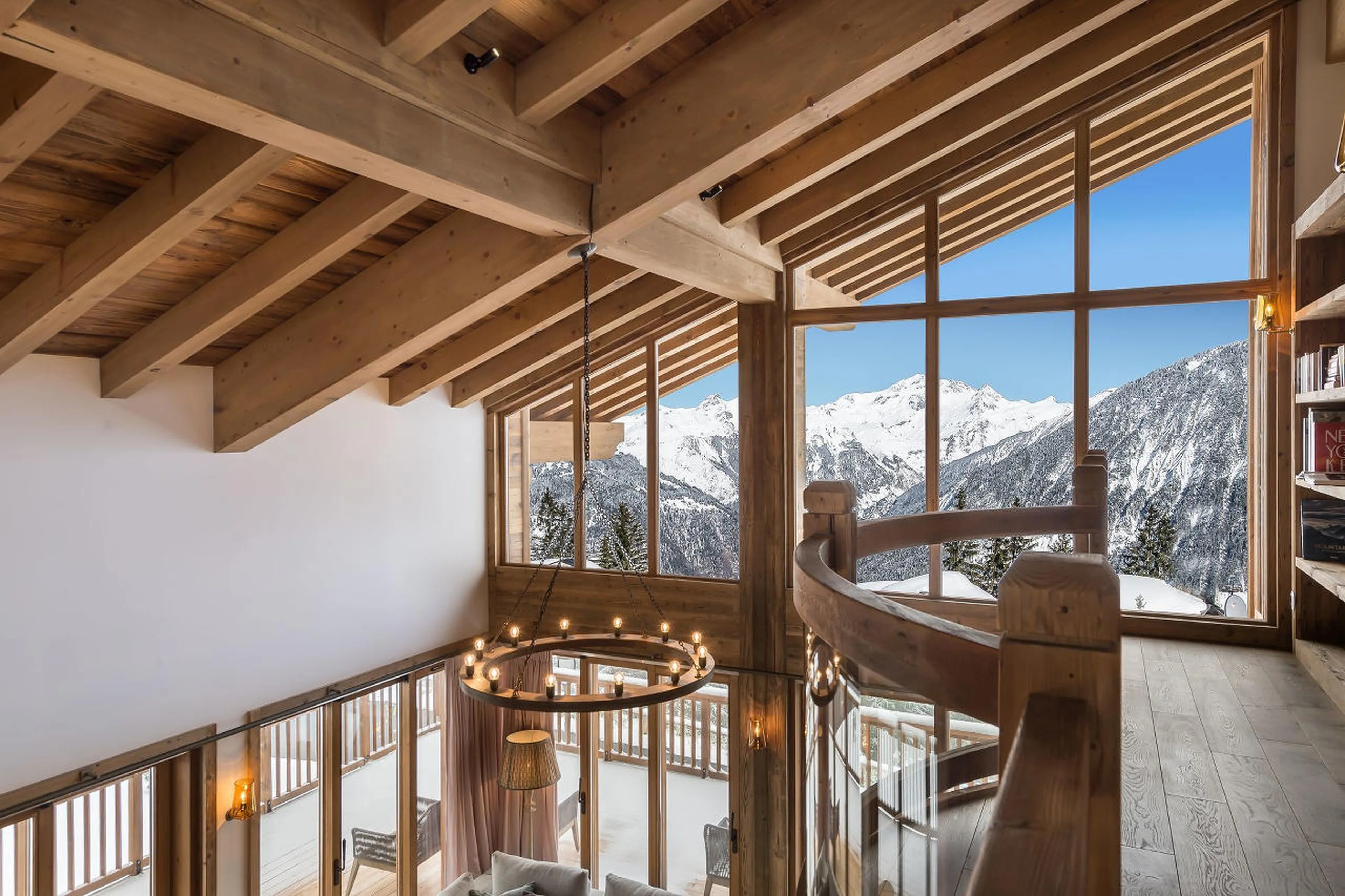 Gallery with a view and bookshelf above living area in Chalet Libellula in Courchevel 1650