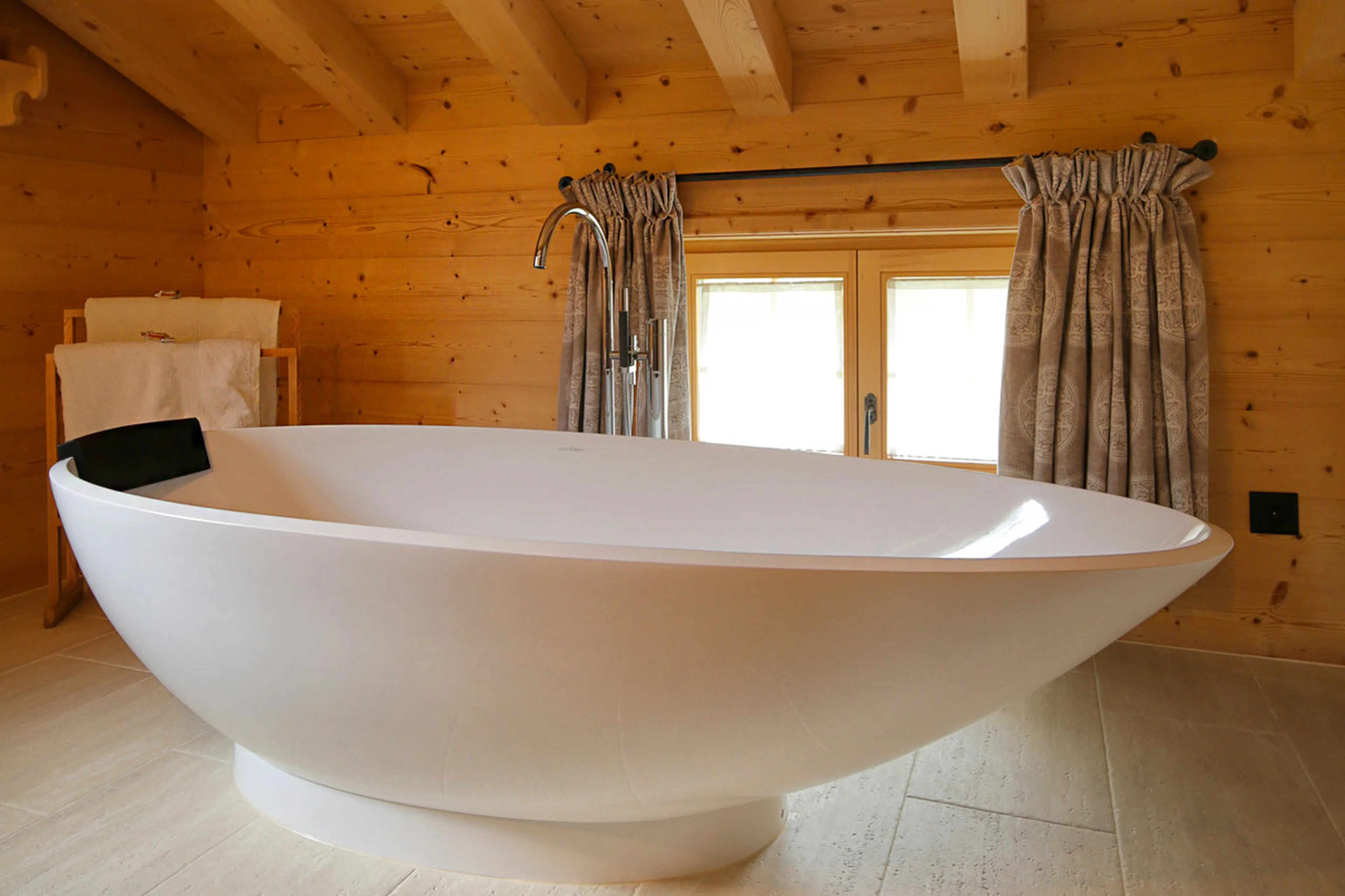 Master bathroom with free standing bath, walk-in shower, double basin in Chalet Luegisland in Kloste