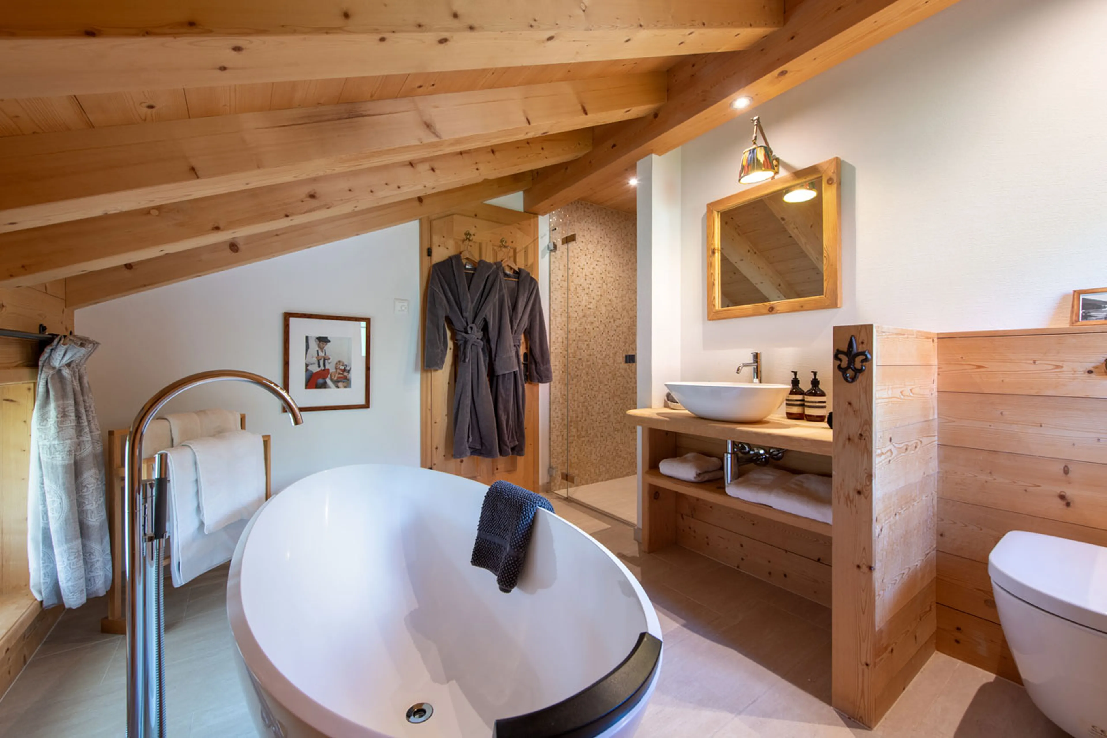 Master bathroom with free standing bath, walk-in shower, double basin in Chalet Luegisland in Kloste