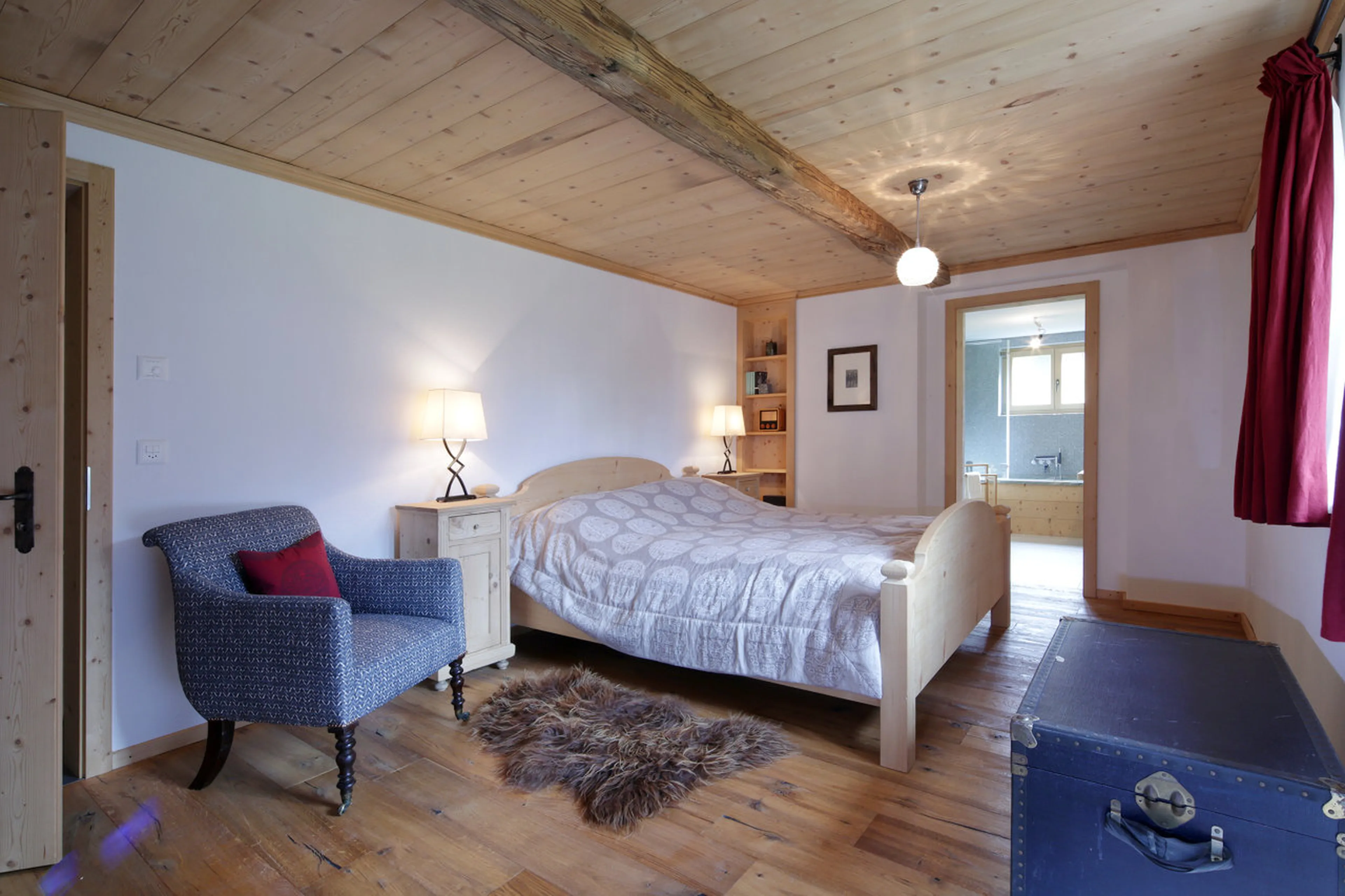 Bedroom with double bed and en-suite bathroom in Chalet Luegisland in Klosters
