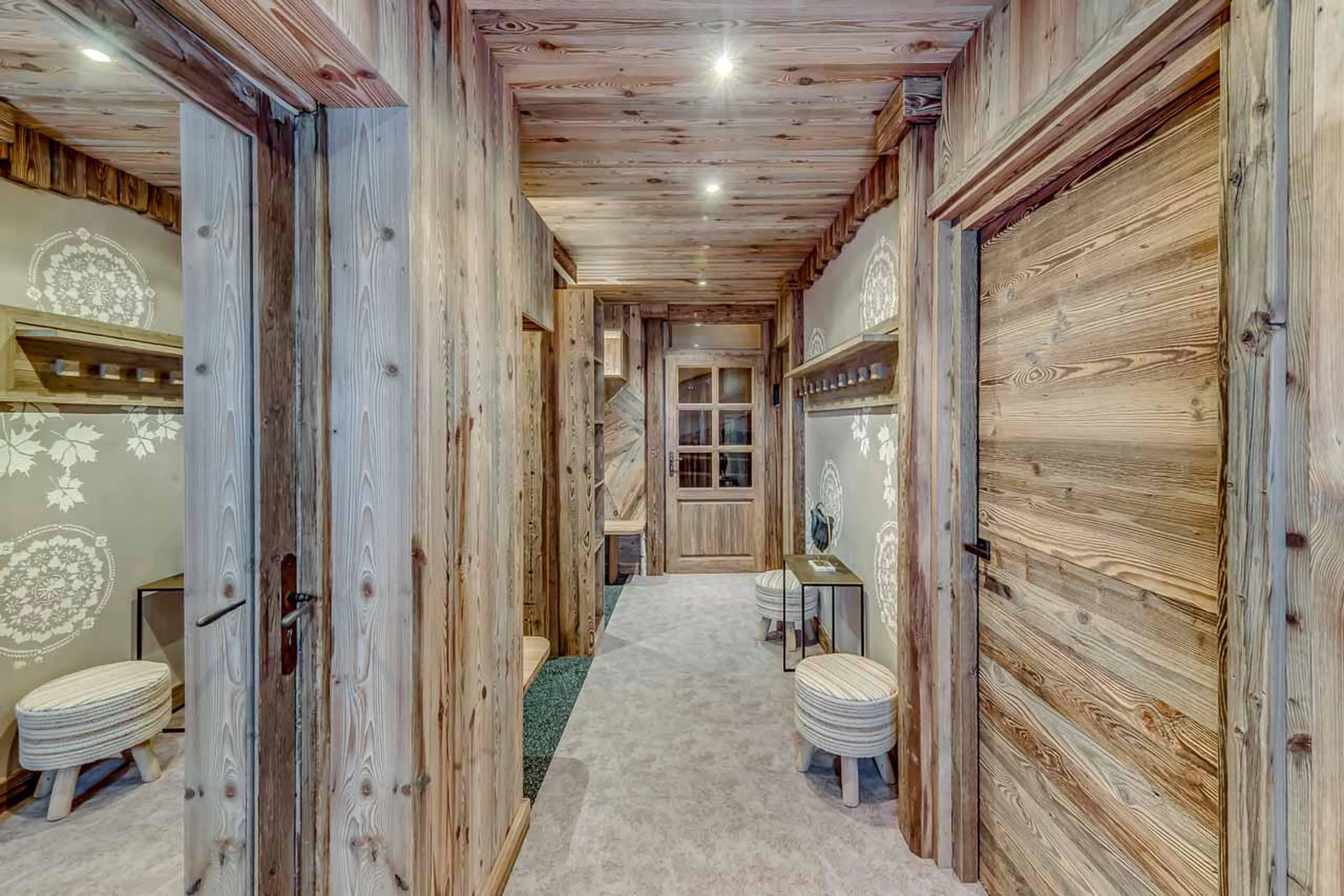 Large entrance with wooden benches, ski lockers and boot drying radiators at Chalet Macha in Tignes