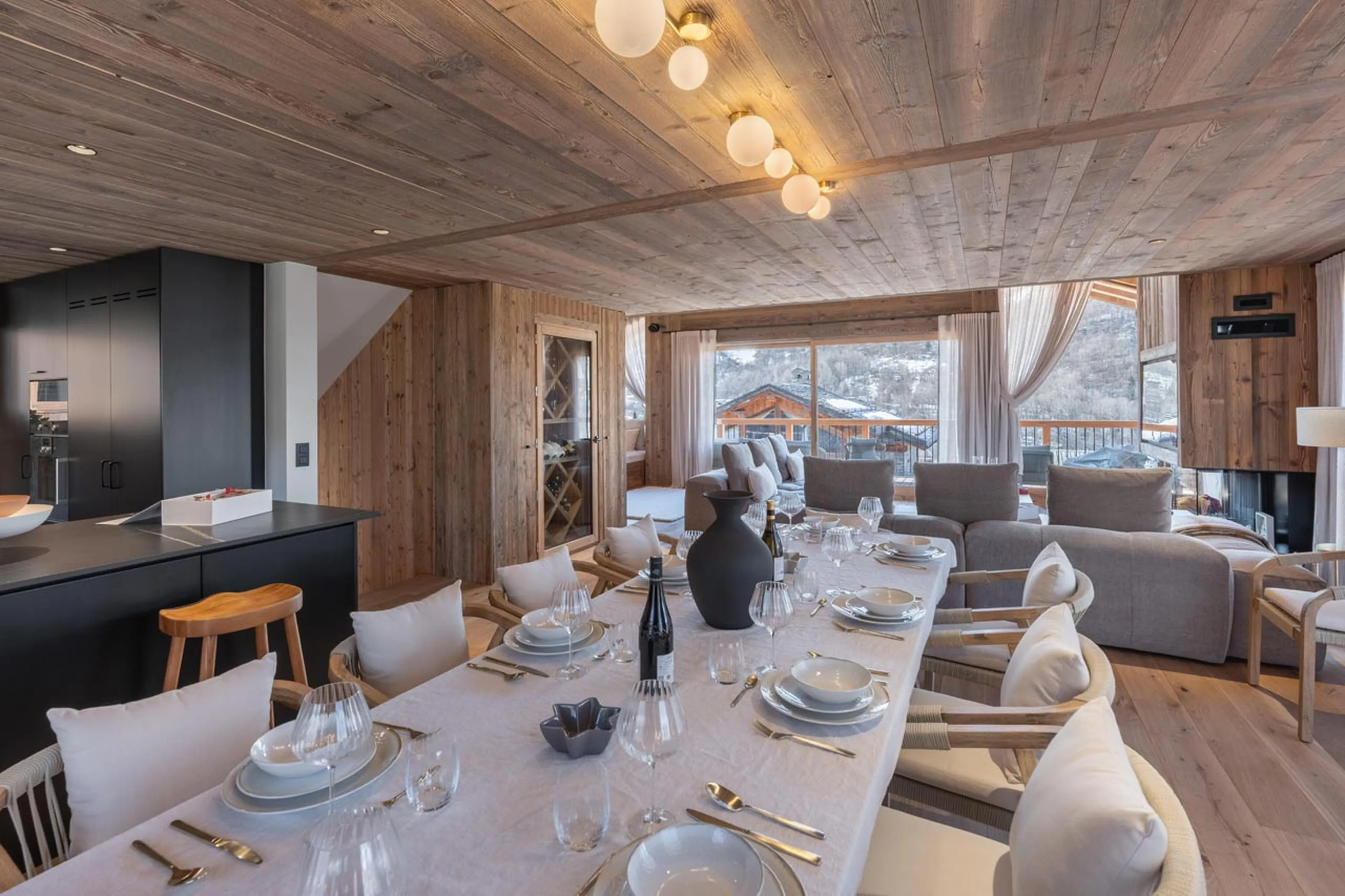 Dining table set beneath sliding glass doors in Chalet Marcel, St Martin de Belleville