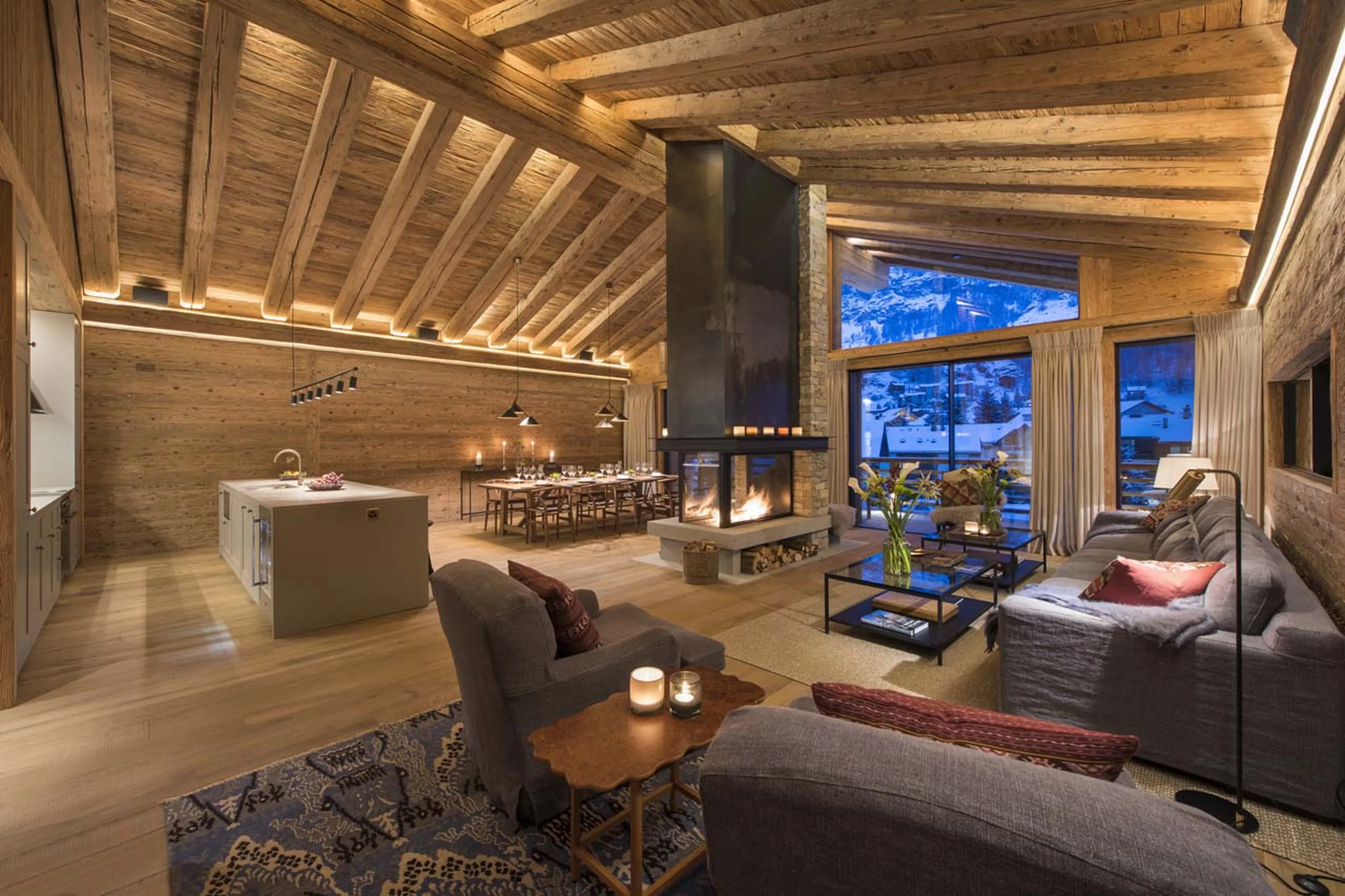 Open plan living and dining area at night of Chalet Mckinley in Zermatt