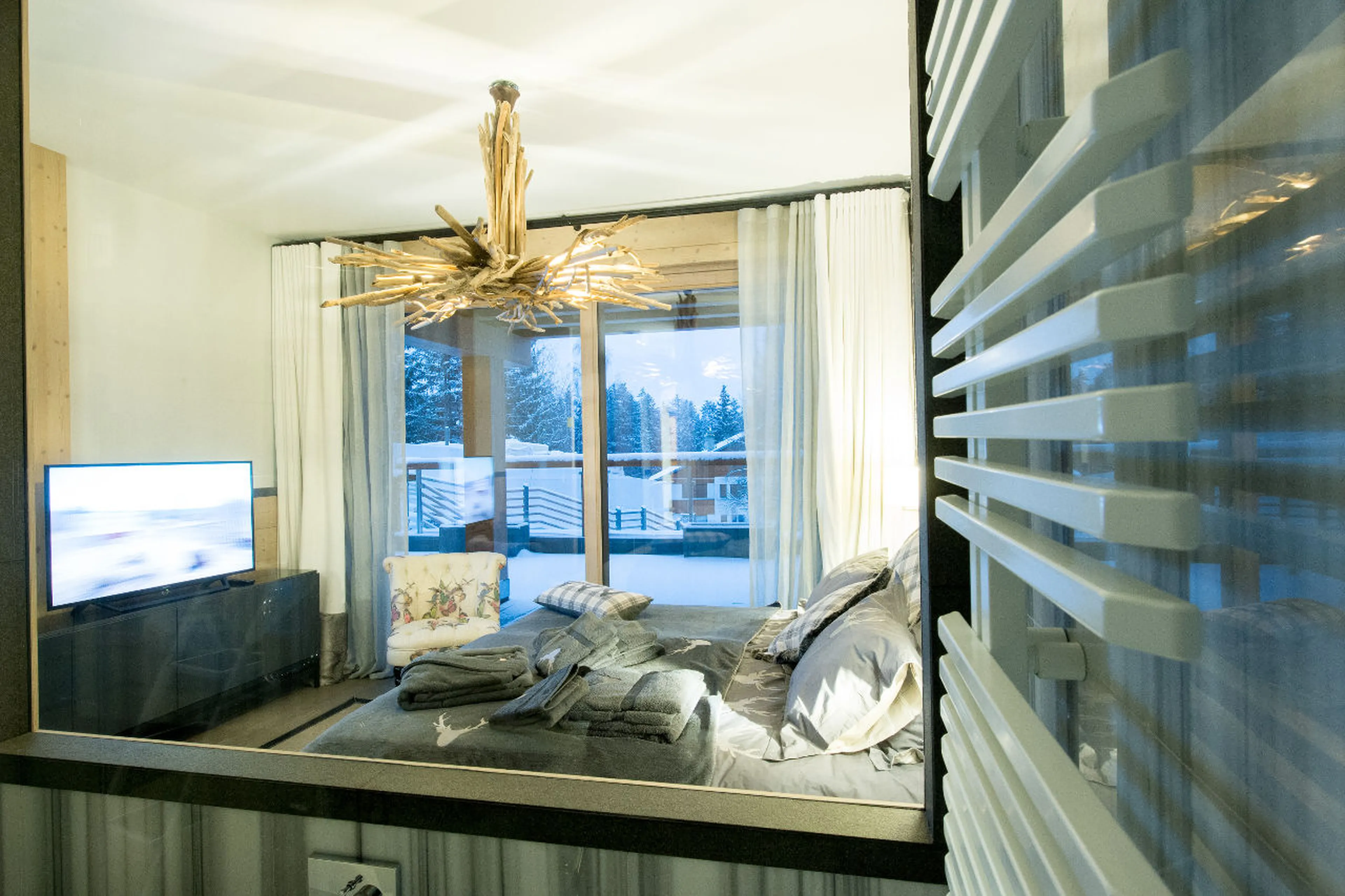 Double bed, TV and terrace from en-suite bathroom in Apartment Aminona in Chalet Migui in Crans-Mont