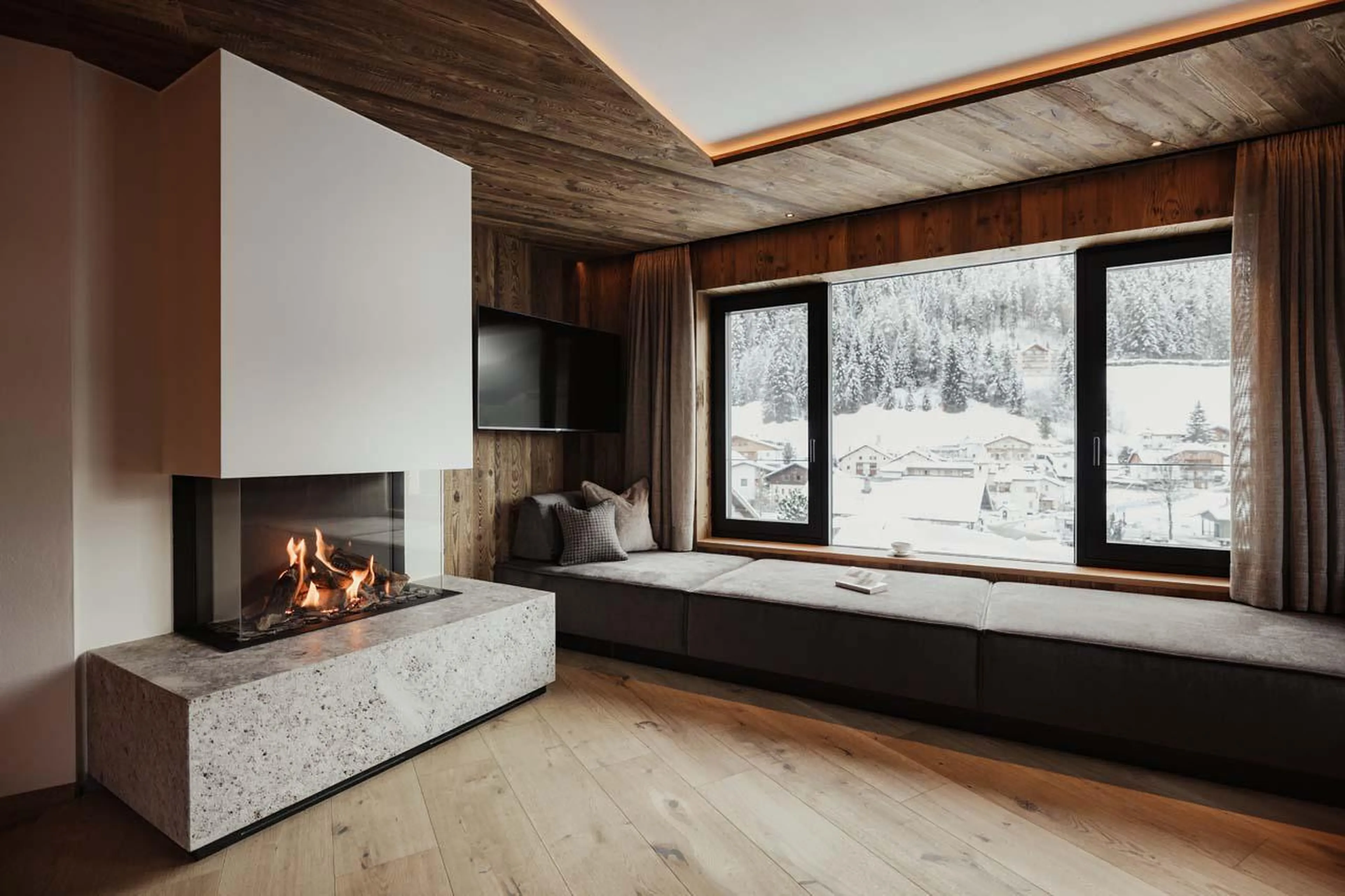 Window seating with TV and fireplace at Chalet Mile 1 in Val Gardena