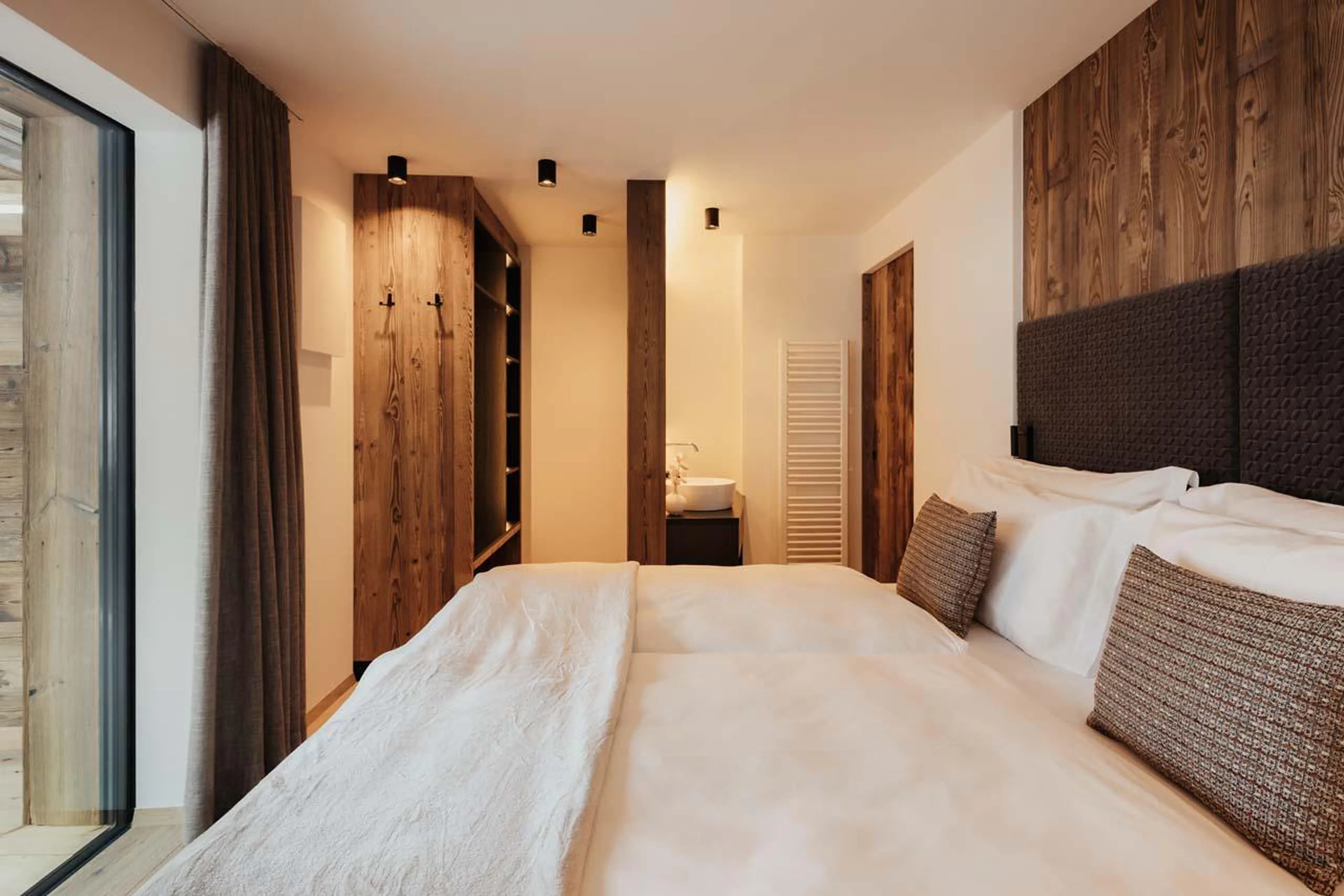 Double/twin bedroom with balcony access and an en-suite shower room at Chalet Mile 2 in Val Gardena