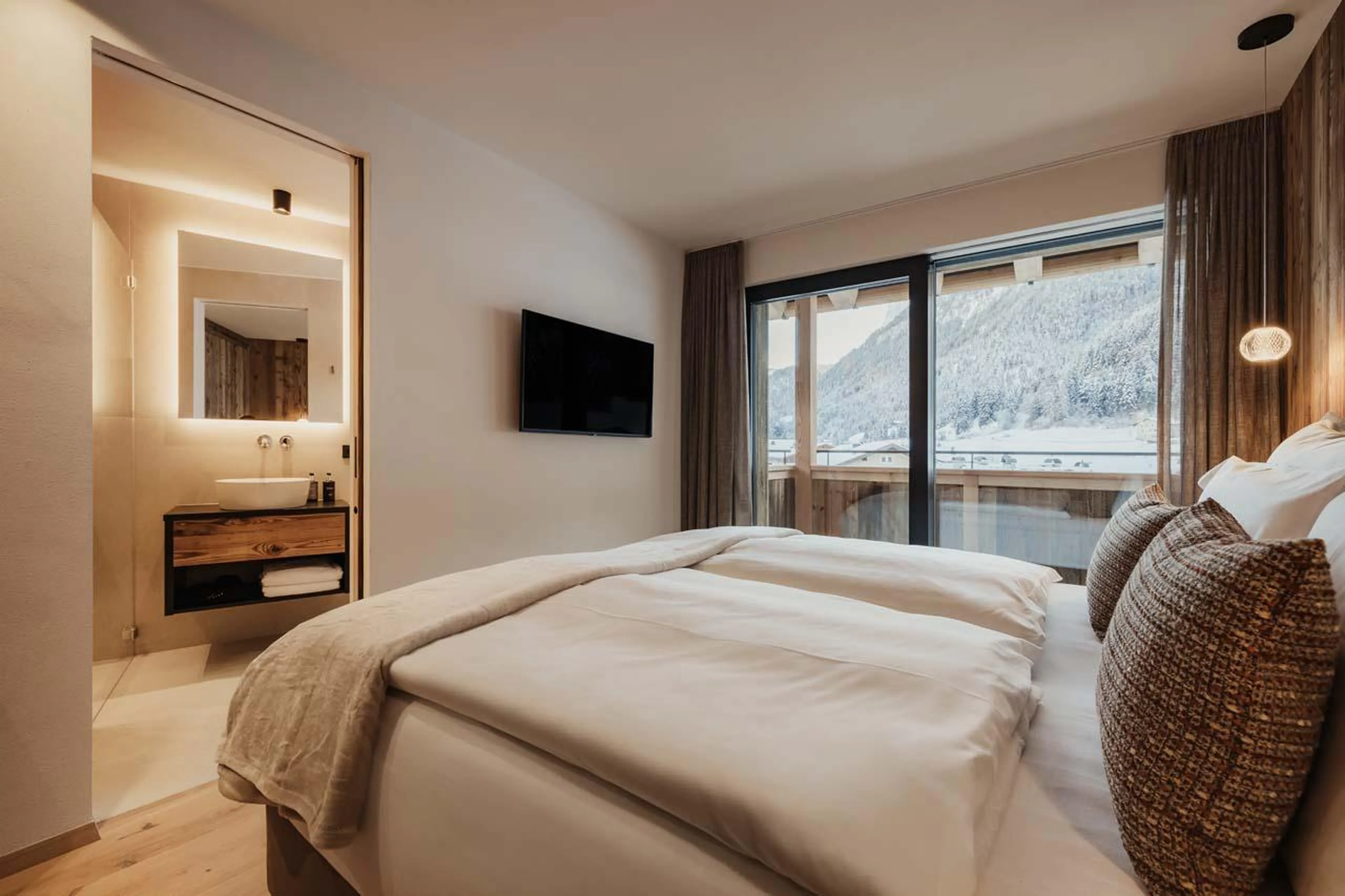 Double/twin bedroom with TV, balcony access and en-suite shower room at Chalet Mile 2 in Val Gardena
