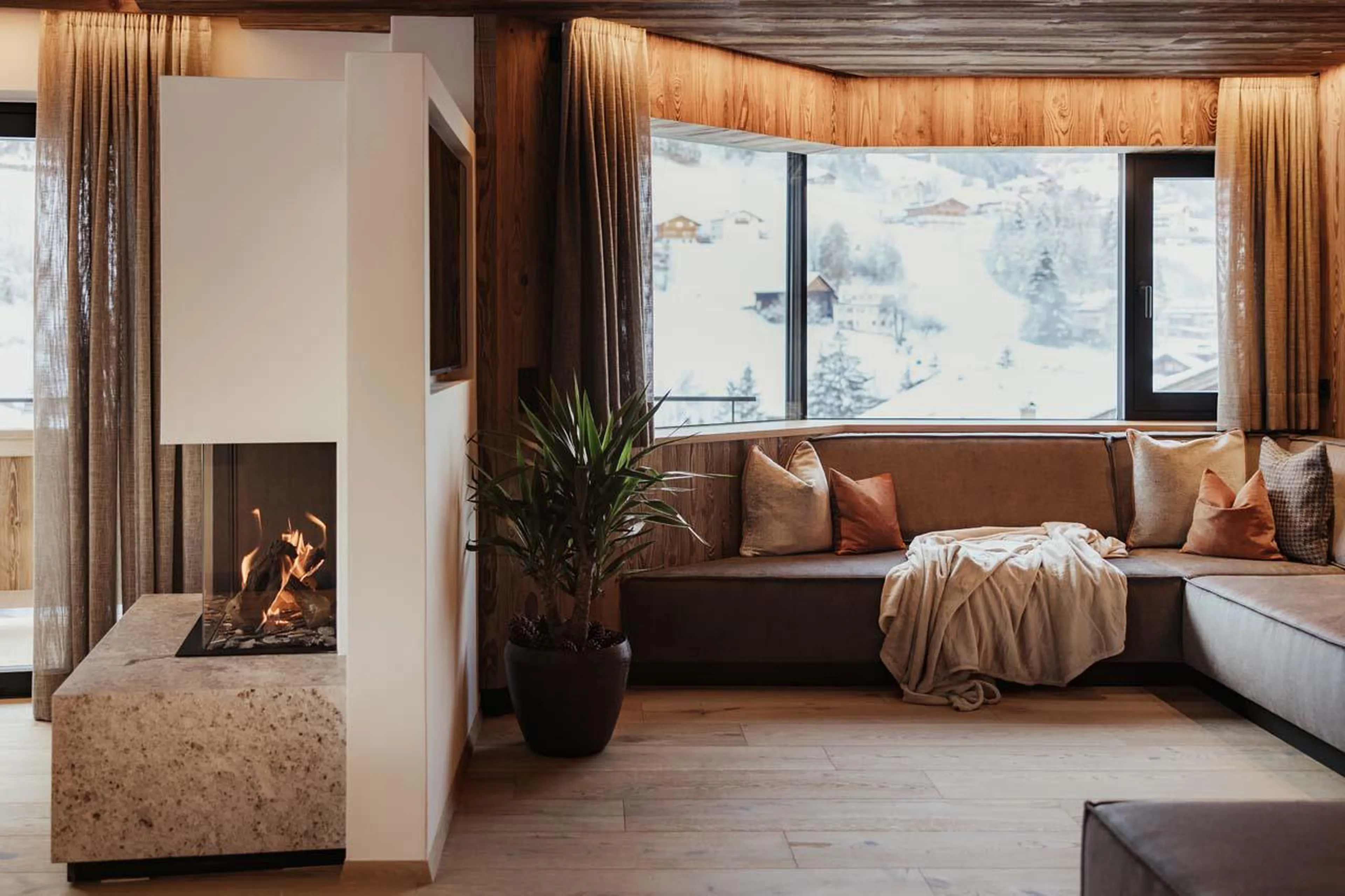 Open-plan living area with cosy sofa corner at Chalet Mile 2 in Val Gardena