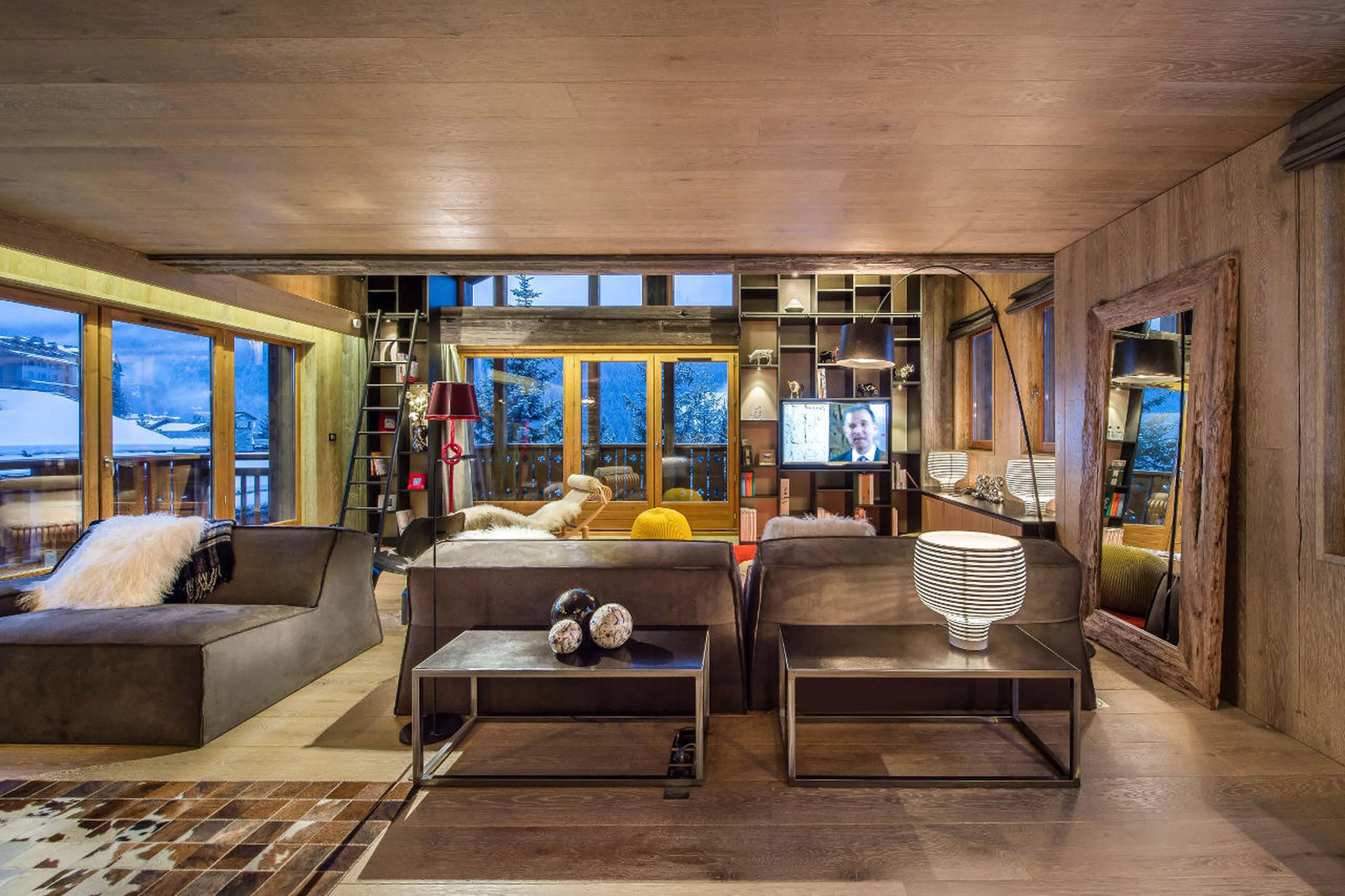 Open fireplace and bookcase in living area of Chalet Overview in Courchevel 1650