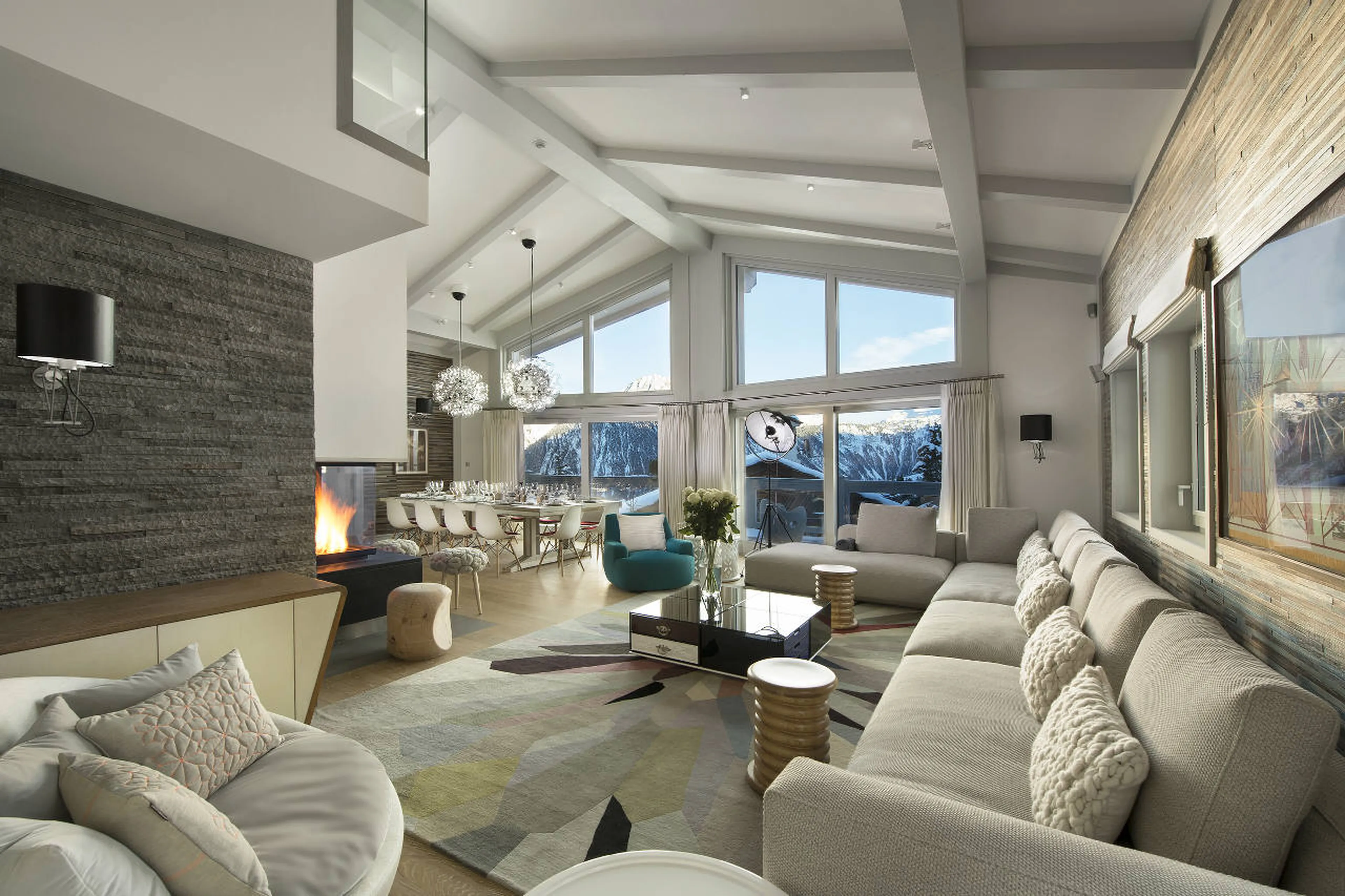 Living area with vaulted ceiling and central fireplace in Chalet Pow Pow, Courchevel 1850