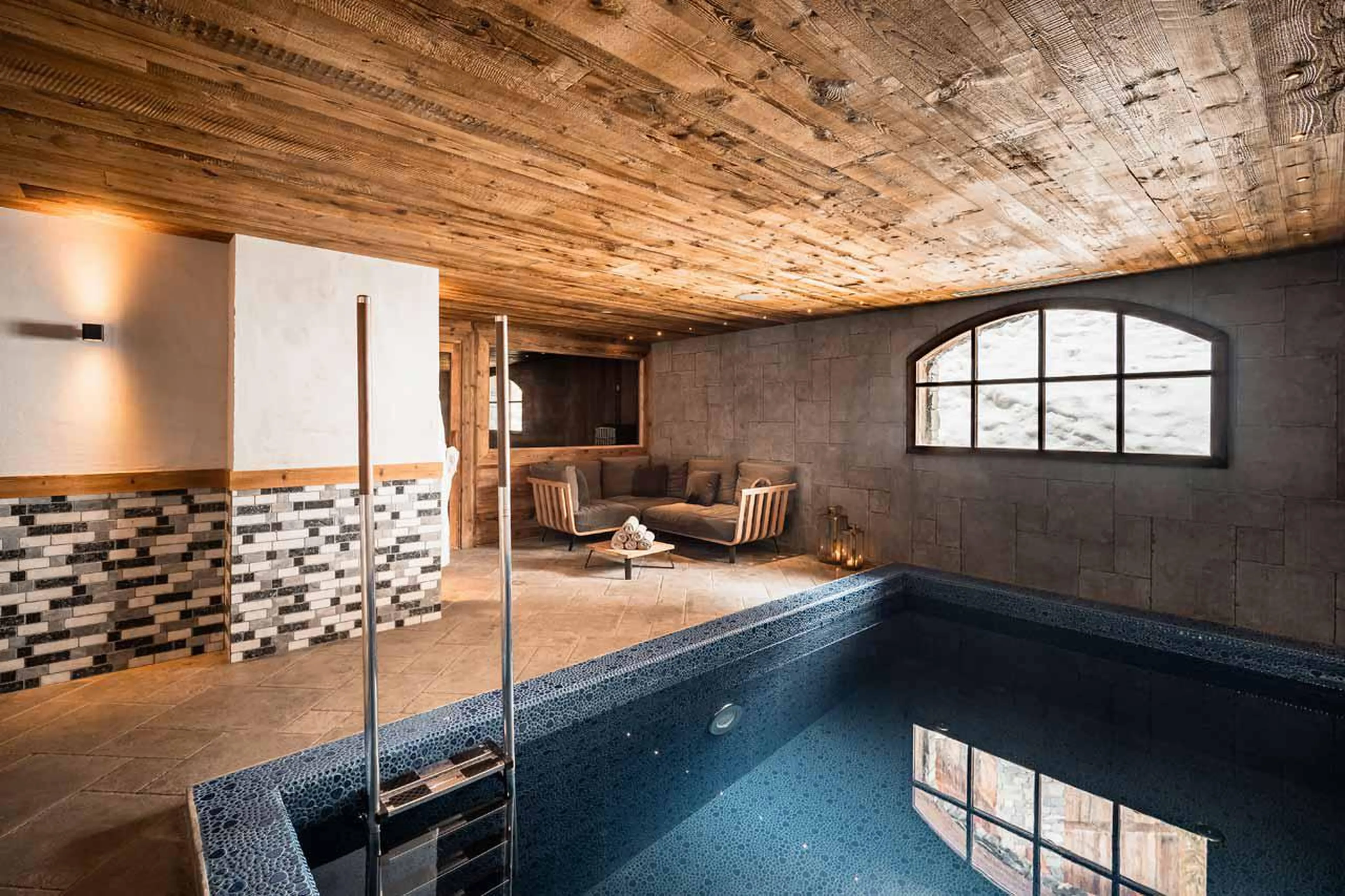 Swimming pool with counter current function and salient tile detail Chalet Sequoia in Val d’ Isere