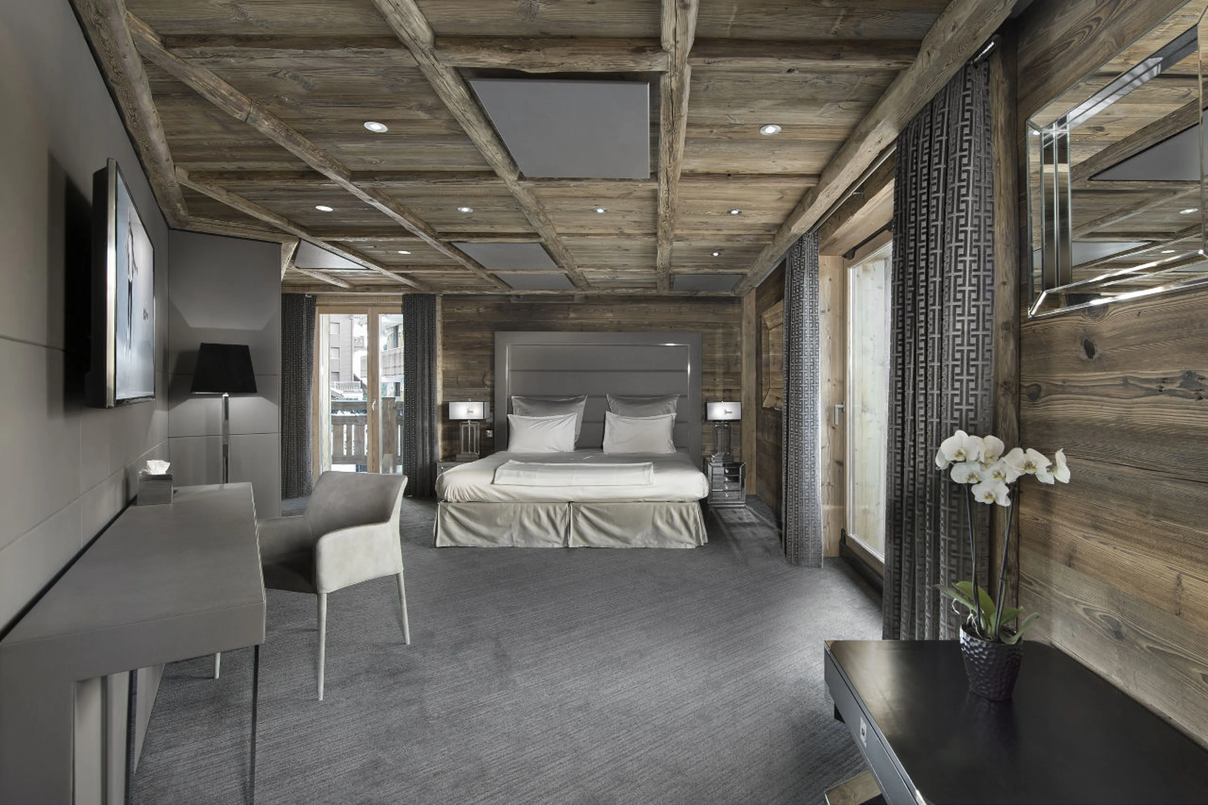 Double bed, dressing area and en-suite bathroom in Chalet Tahoe in Courchevel 1850