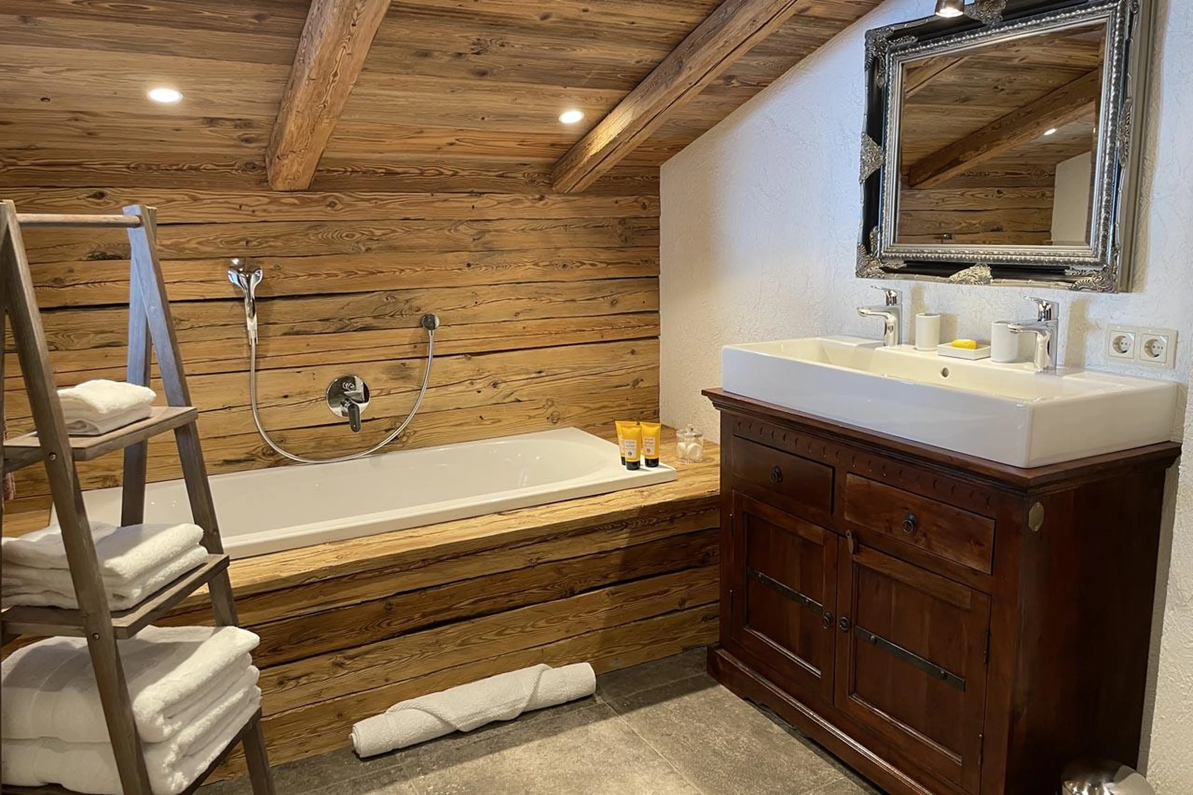 En-suite bathroom with bath and shower at Chalet Tschoder in St Anton
