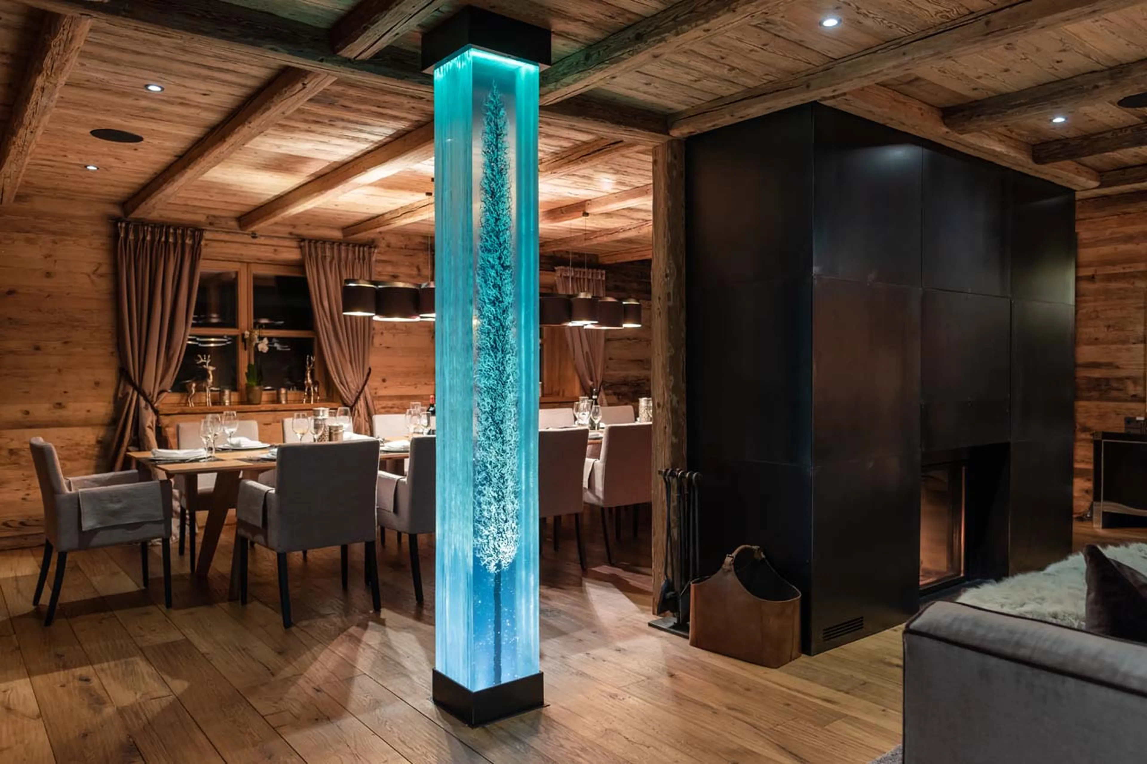Fireplace dividing living and dining area at Chalet Uberhaus in Lech