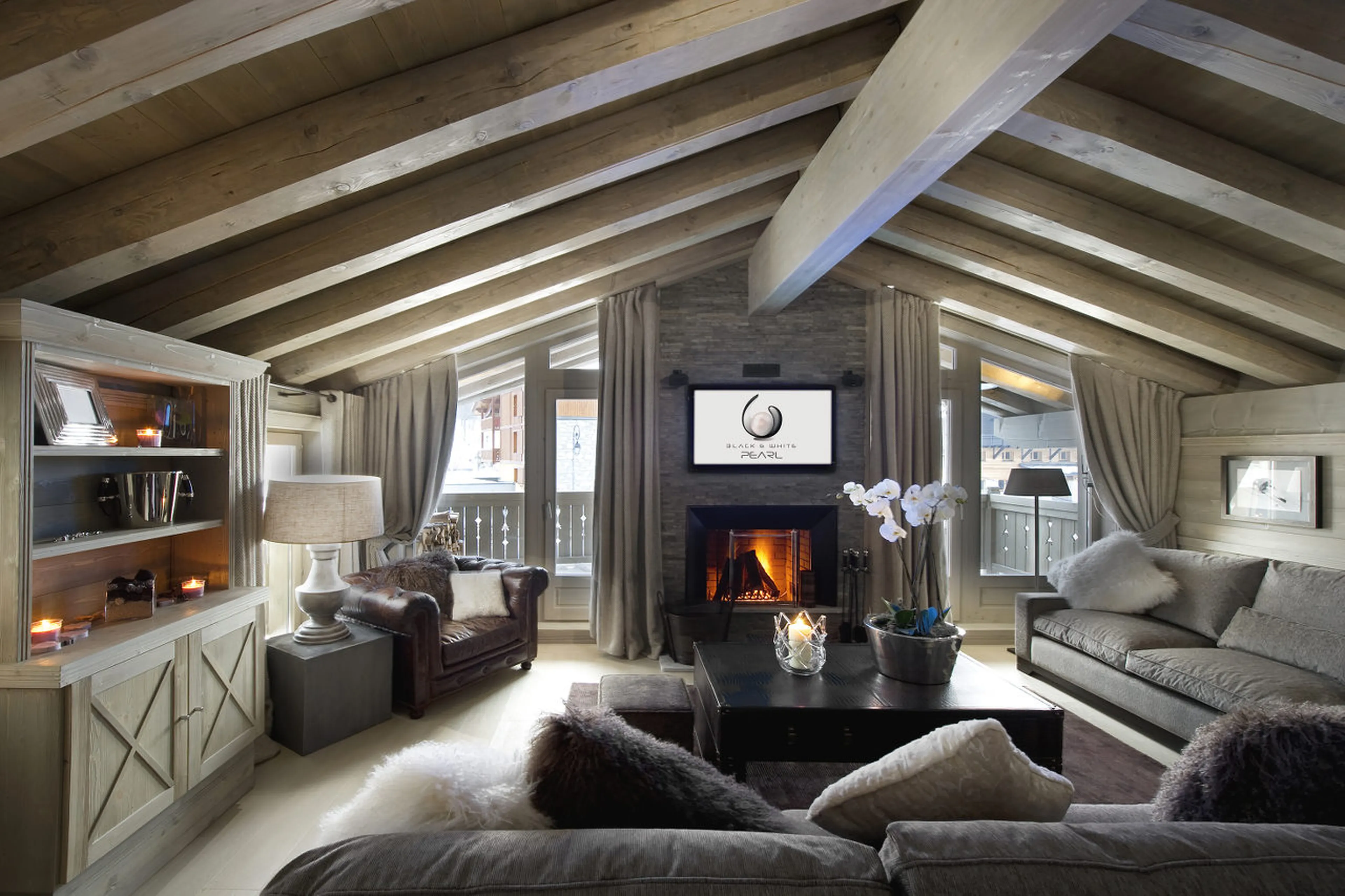 Lounge with fireplace and vaulted ceiling in Chalet White Pearl in Val d’Isere