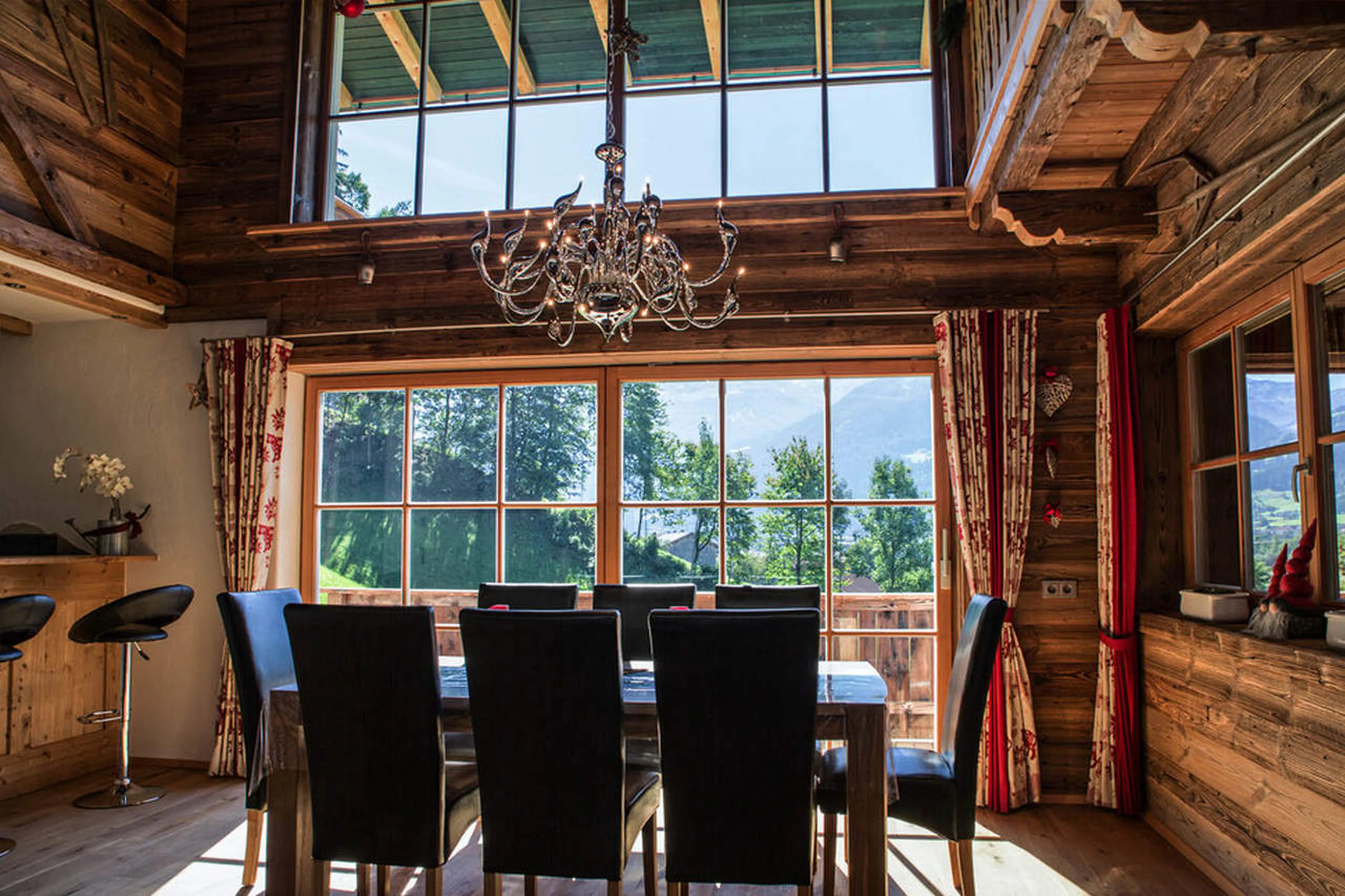 Floor-to-ceiling windows and balcony access from dining area in Chalet Ziller in Zillertal