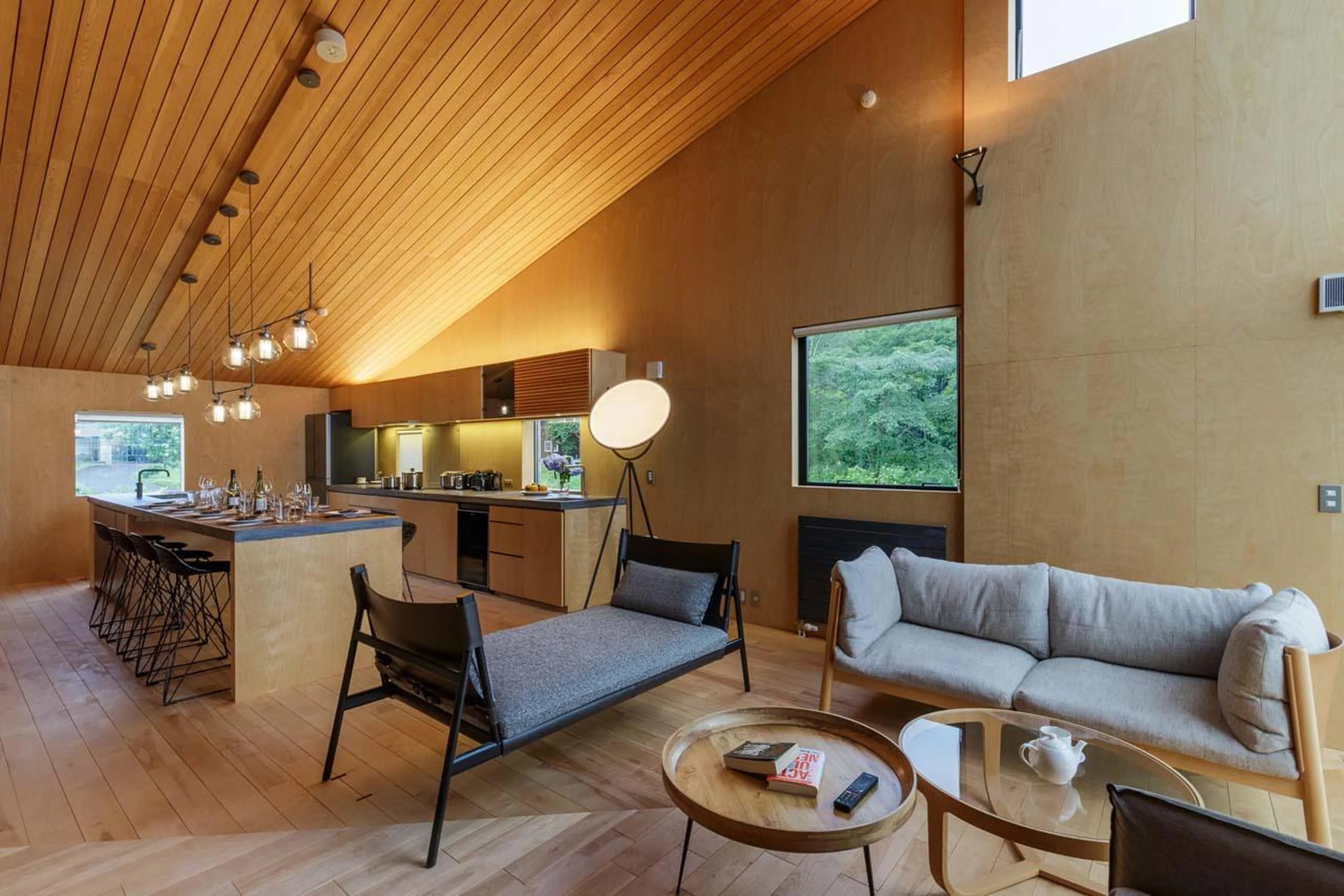 Open-plan living room with sofas, kitchen and dining table at Chalet Foxwood E in Niseko