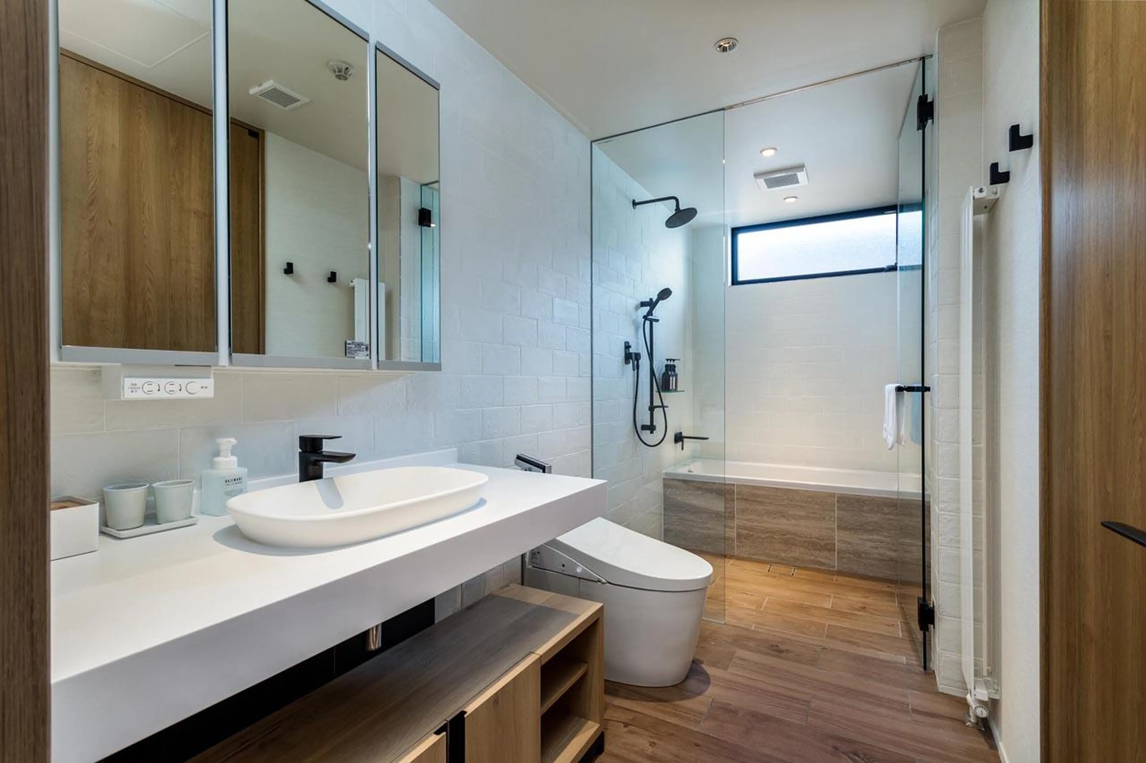 En-suite bathroom with bath and separate shower at Koa Townhouse in Niseko