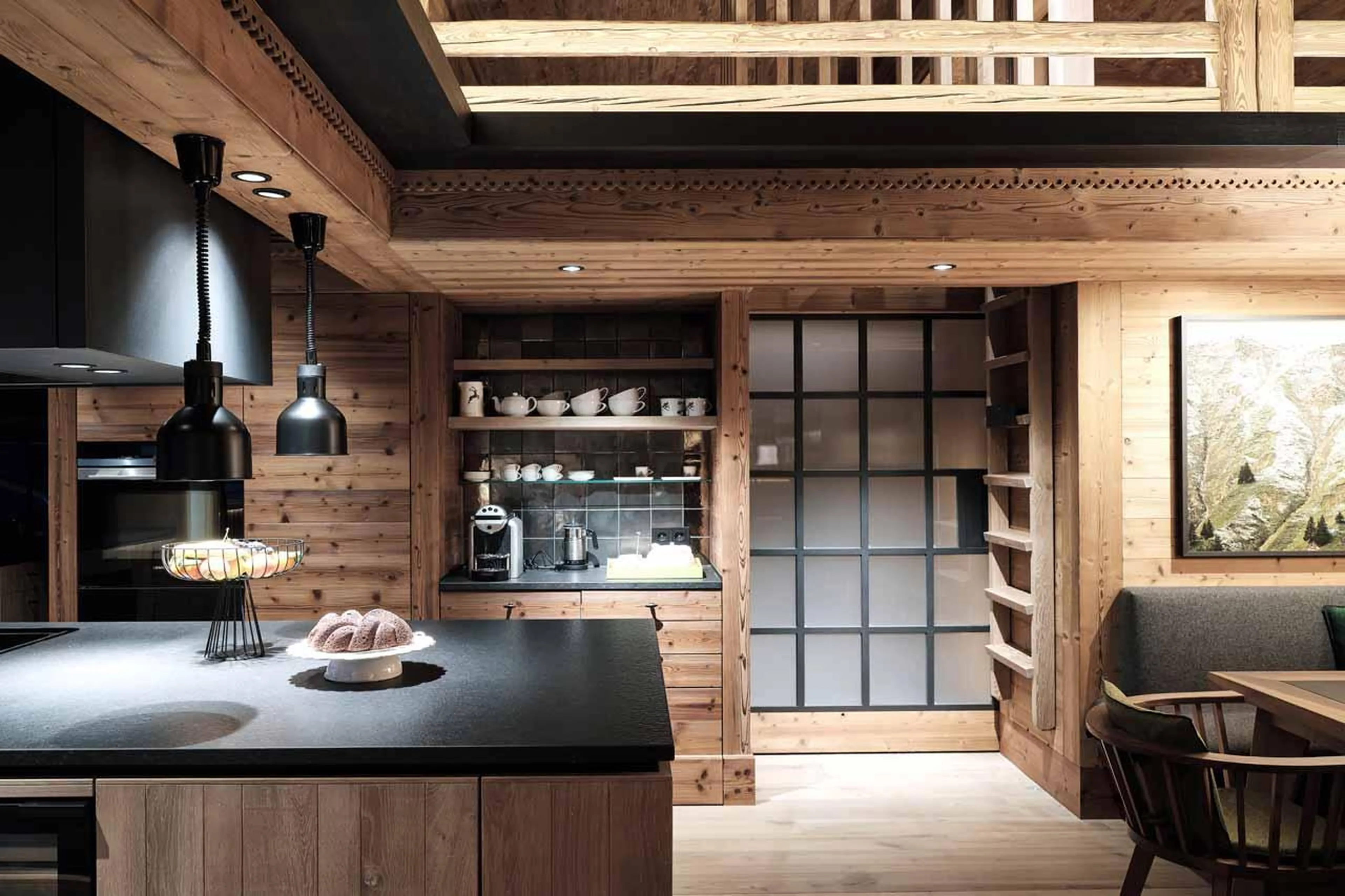 Sleek kitchen with wooden facade and black counter tops in Lech Lodge Loft, Lech