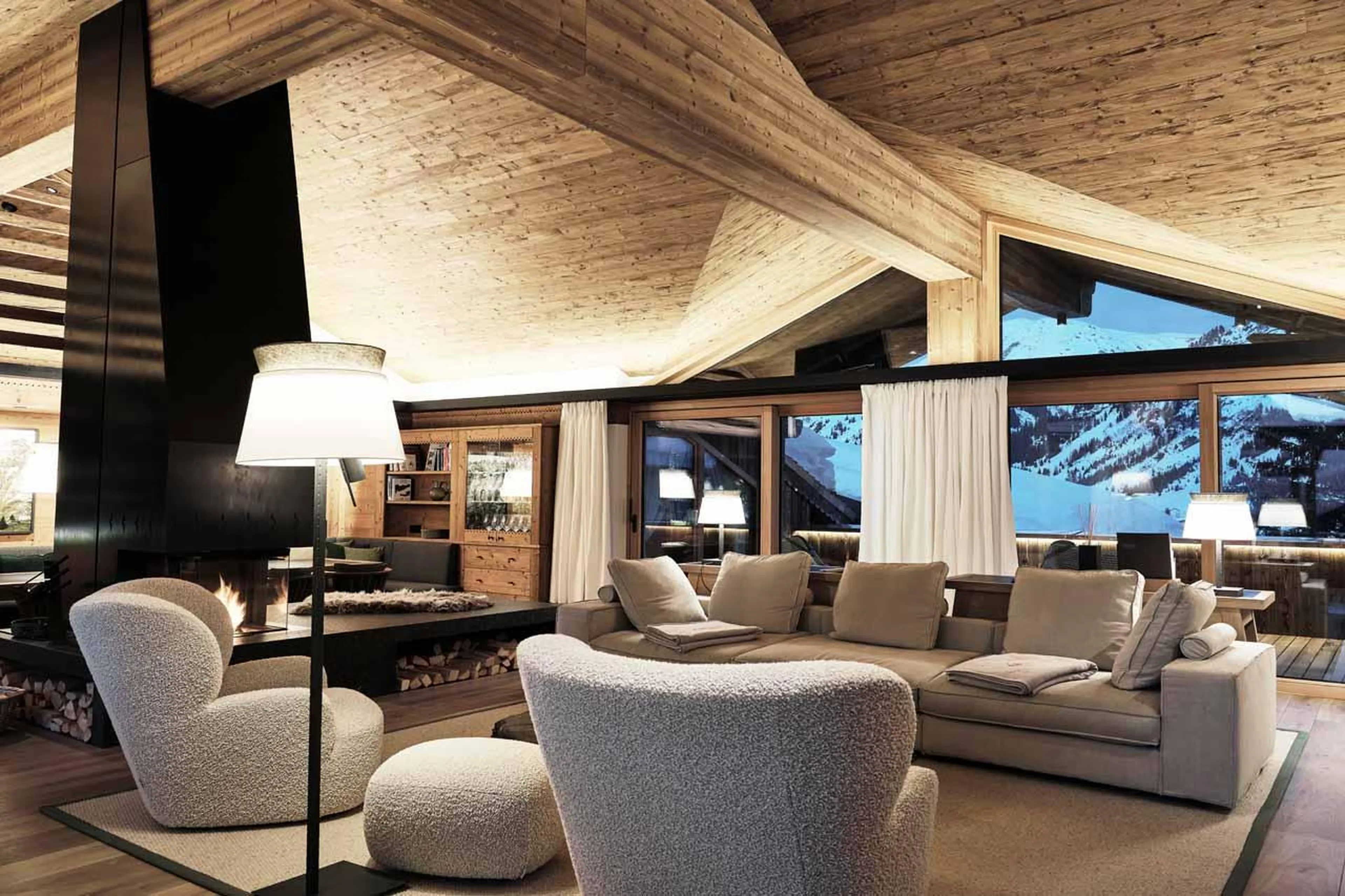 Armchairs and sofas in front of sliding glass doors leading to balcony in Lech Lodge Loft, Lech