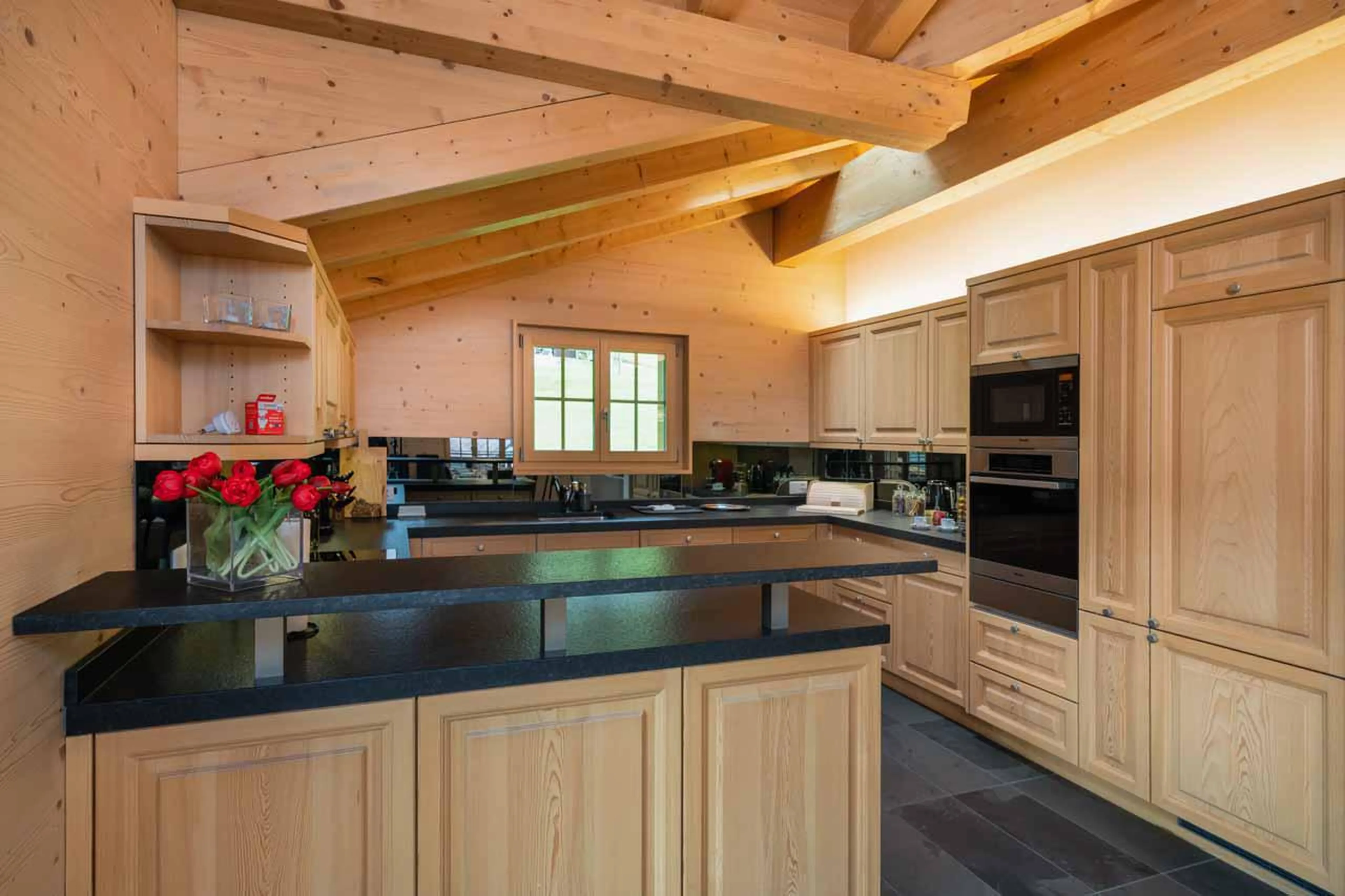 Well-equipped kitchen space adjoining the living area at Chalet Alia in Grindelwald