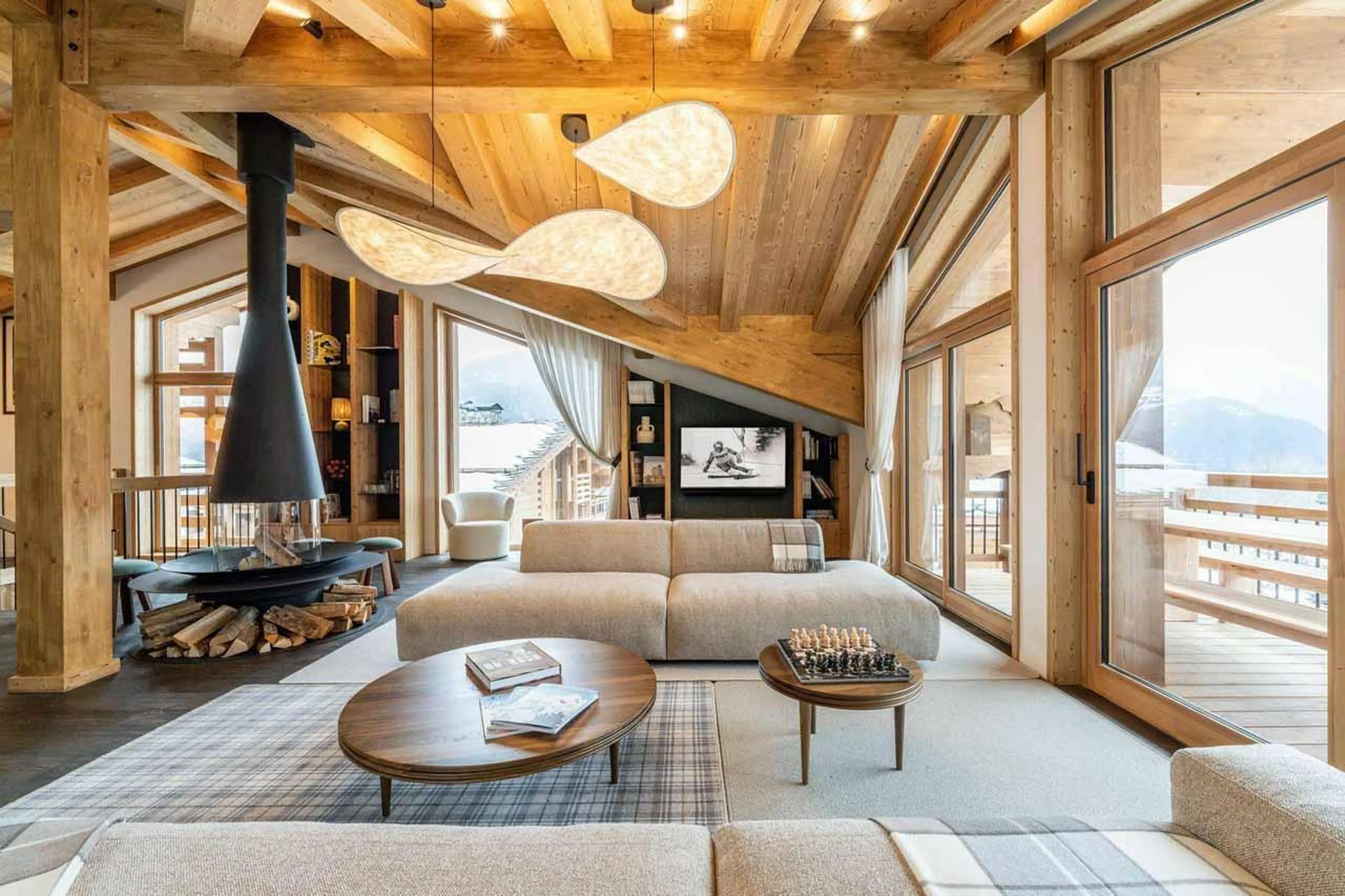Fireplace, sofas and glass doors in Chalet Beloukha, Courchevel Le Praz