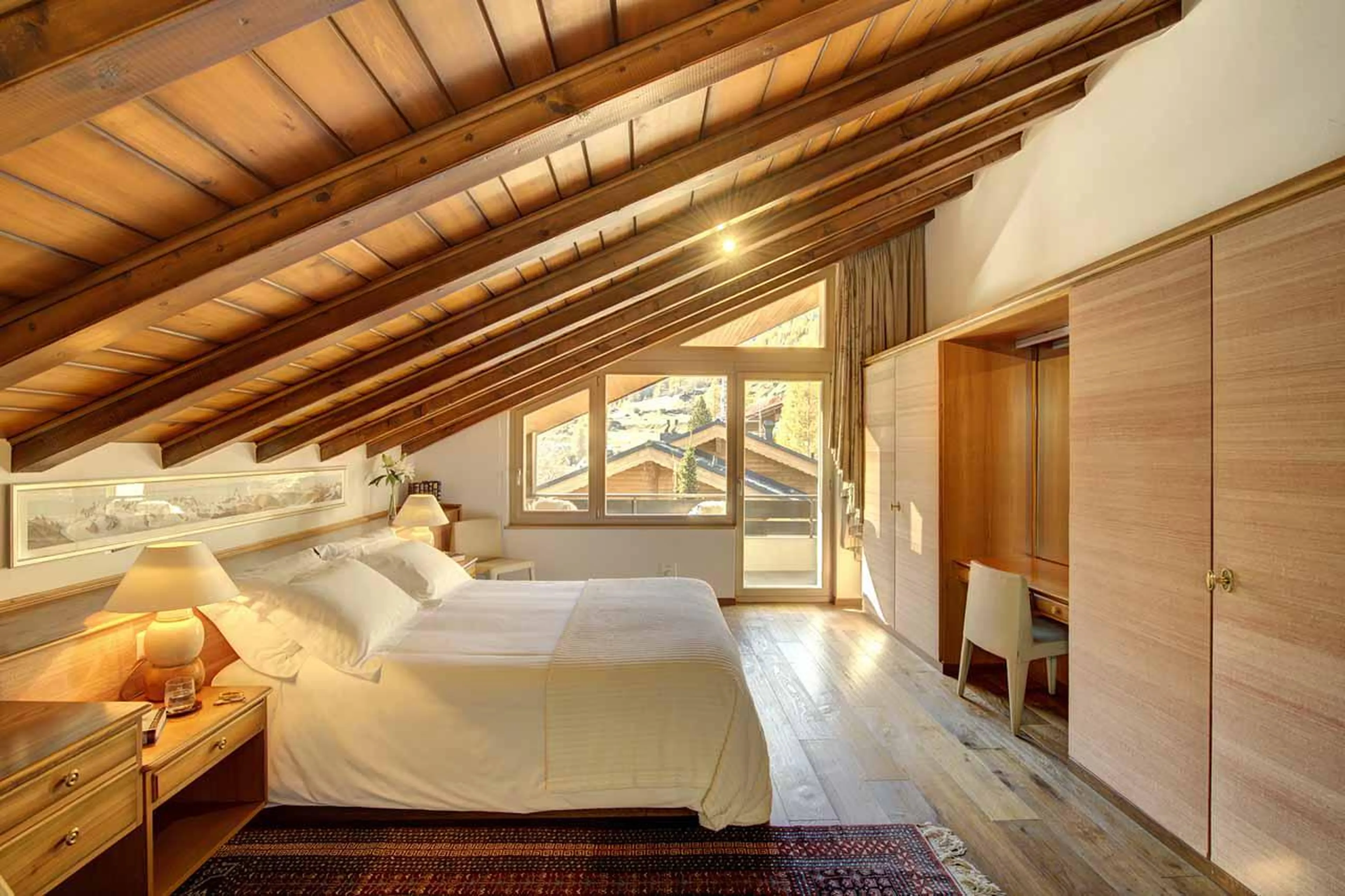 Spacious master bedroom with balcony & en-suite bathroom at Penthouse Zen in Zermatt
