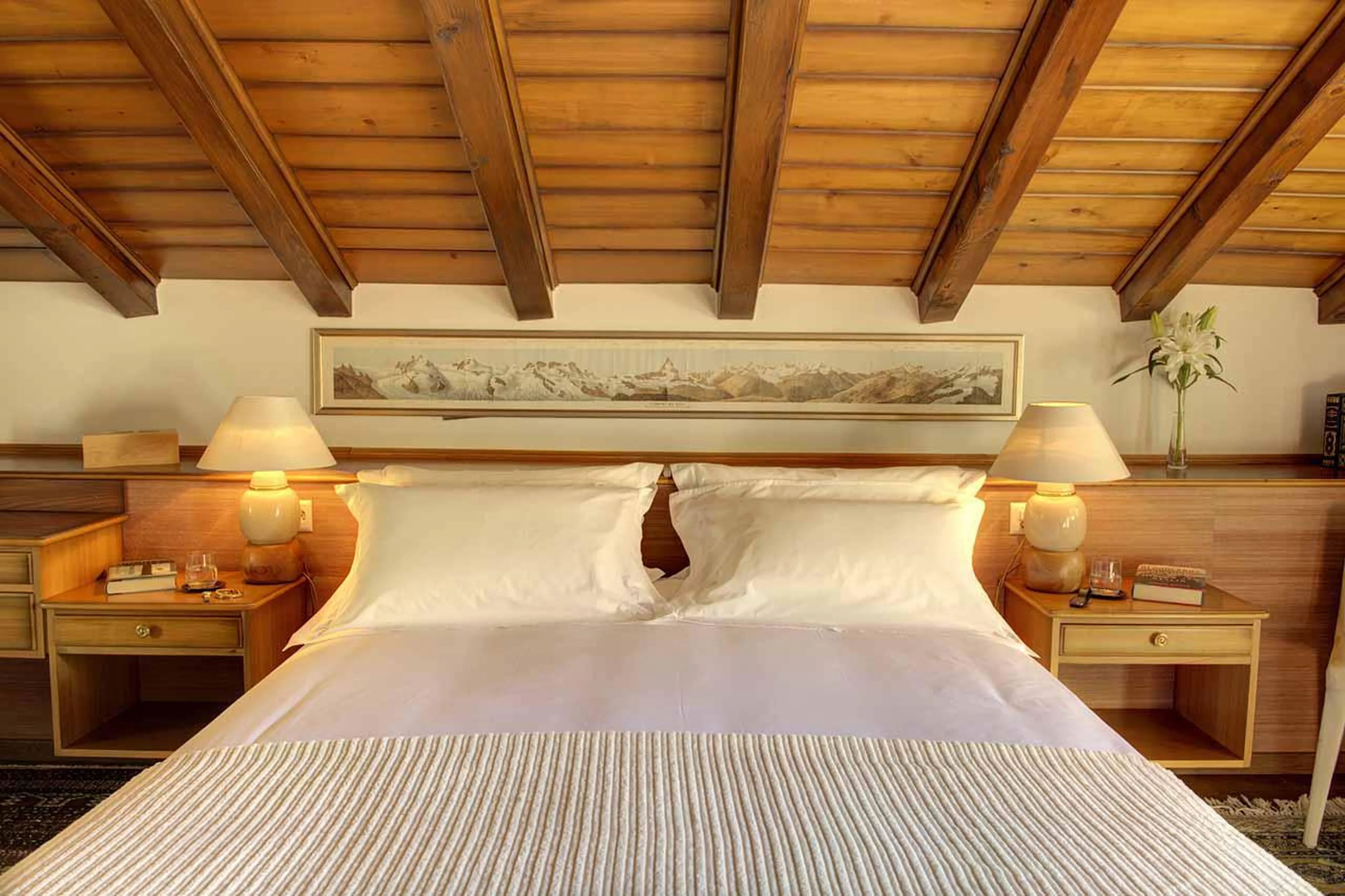 Master bedroom with wood-beamed ceiling at Penthouse Zen in Zermatt