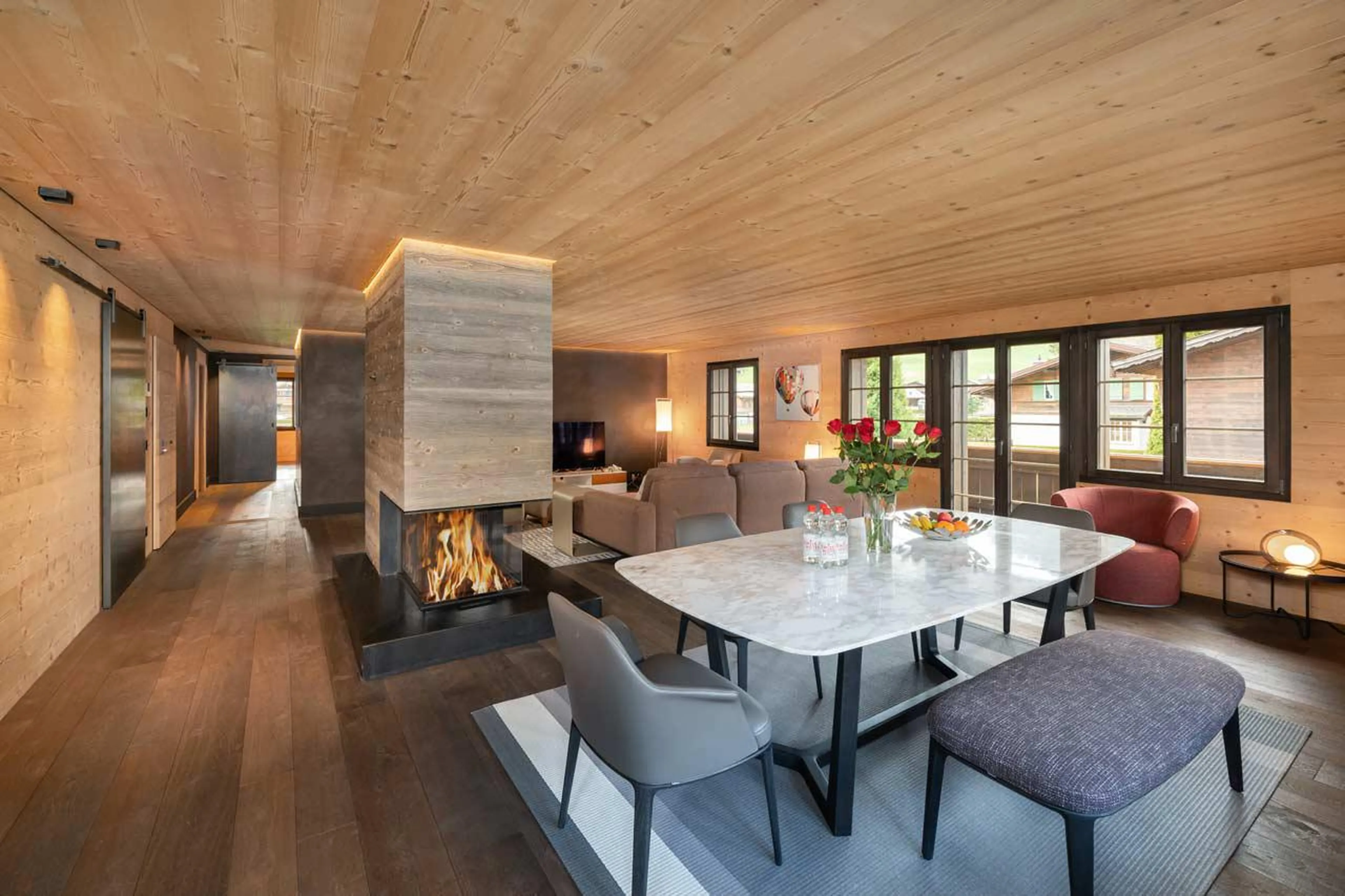 Living area with central fireplace at Apartment Eggli in Gstaad