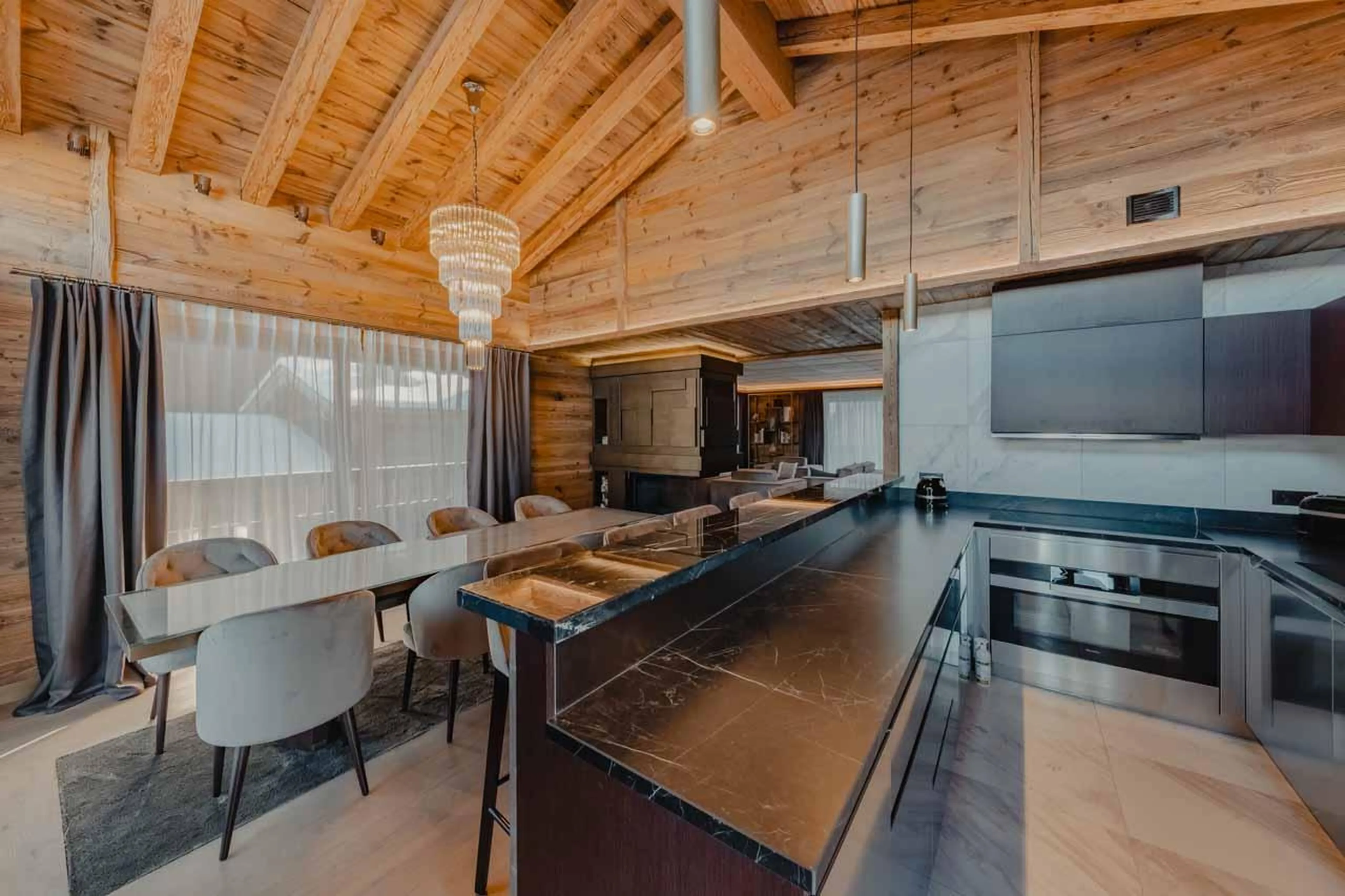 Kitchen with breakfast bar and dining table at Ultima Courchevel Belvedere in Courchevel 1650