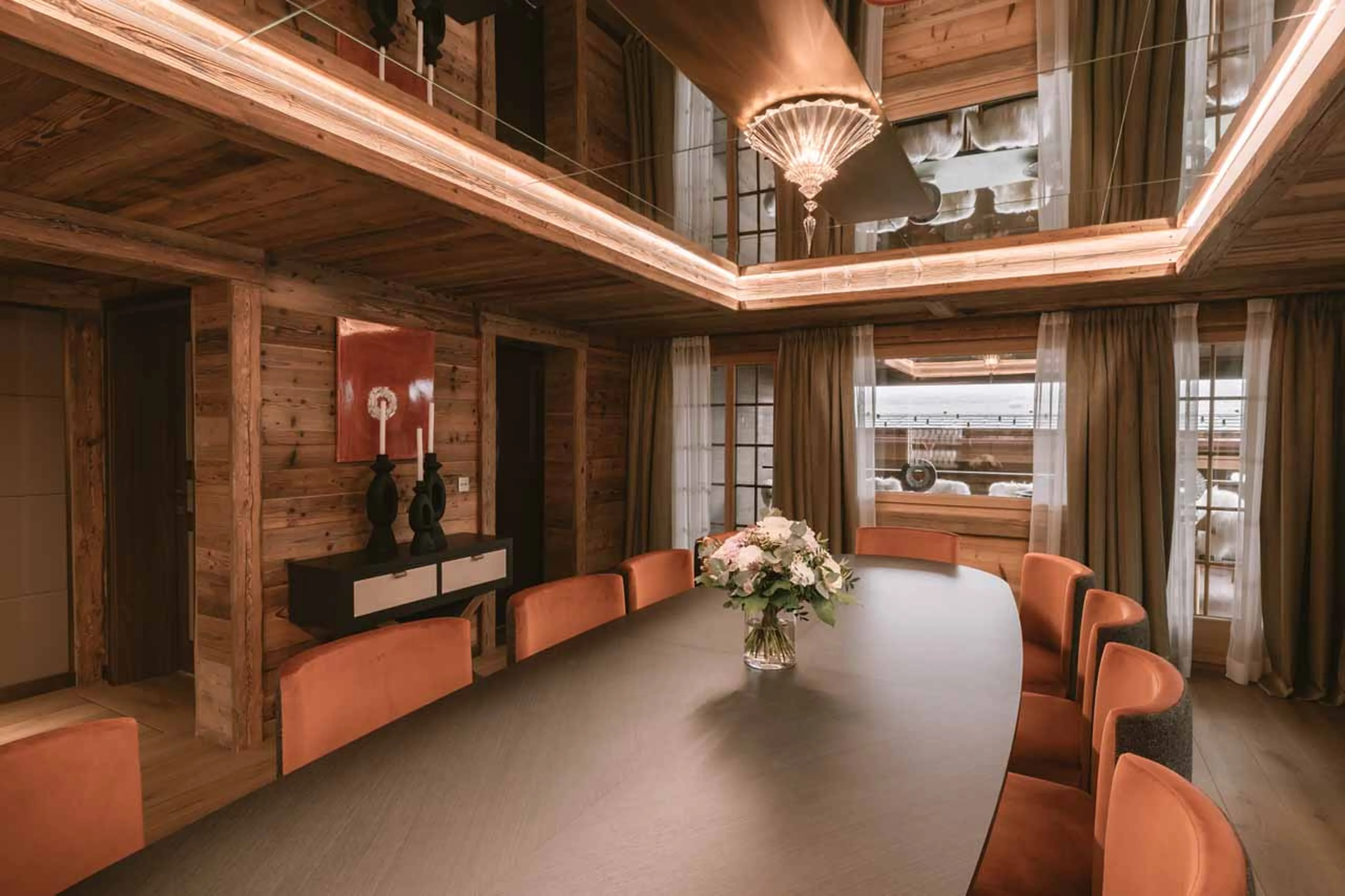 Elegant dining room with two-storey windows in Ultima Gstaad Promenade, Gstaad