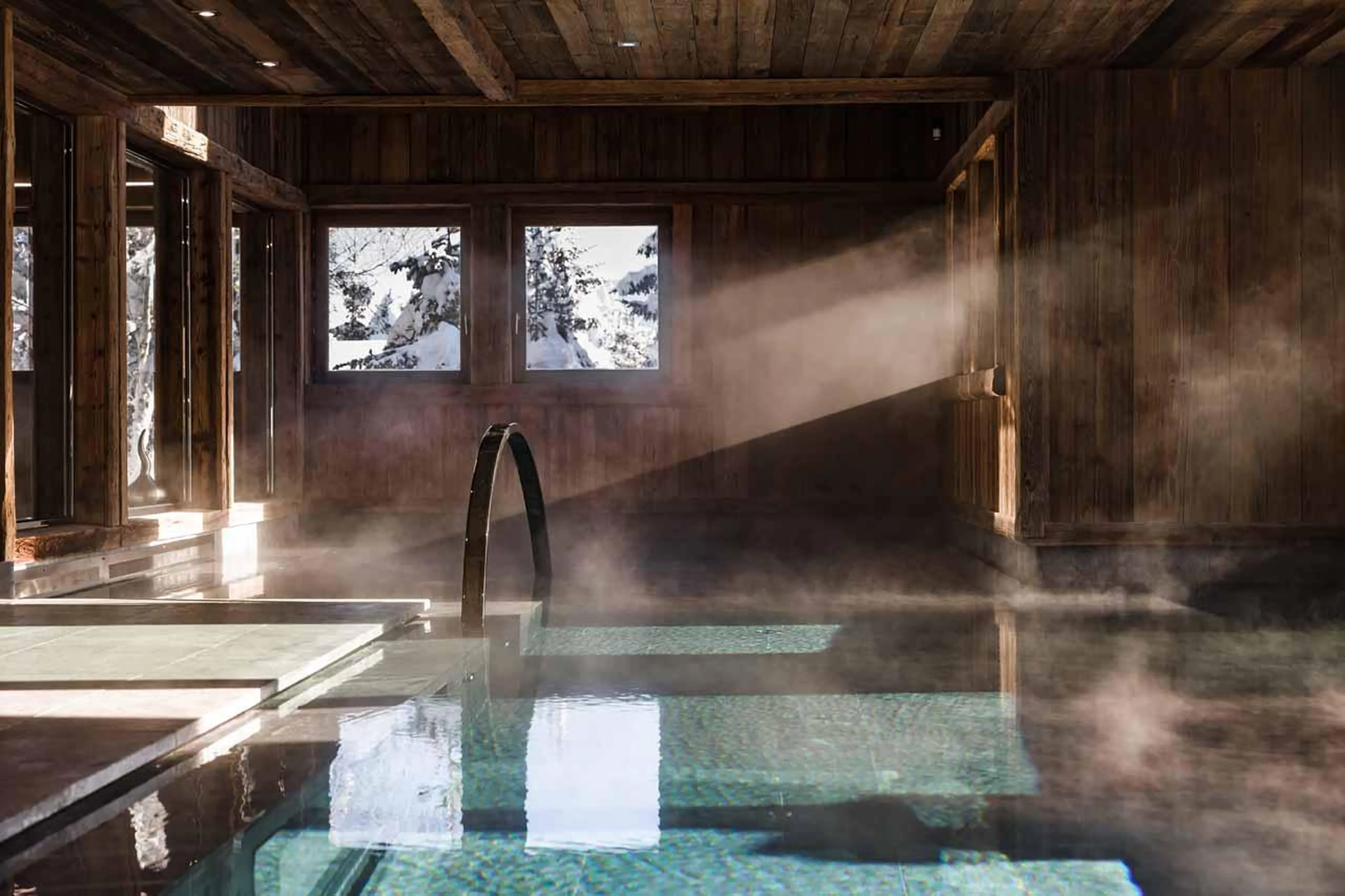Indoor swimming pool within tranquil spa area at Ultima Megeve